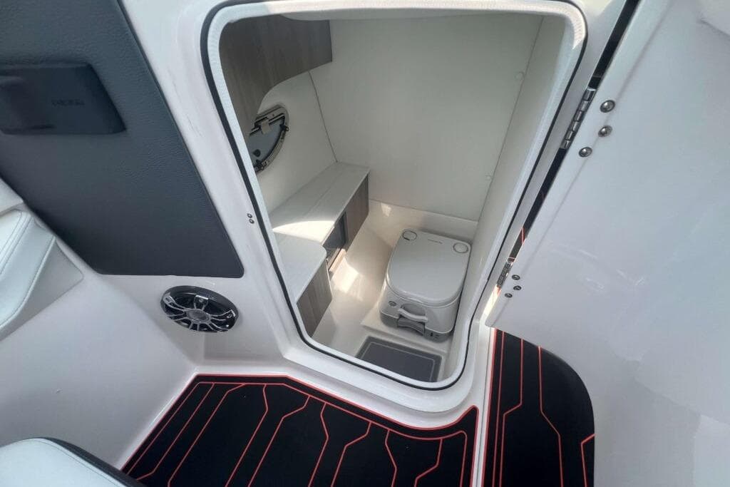 Compact bathroom inside 2023 Regal LS6 Surf boat, featuring modern amenities and sleek design.