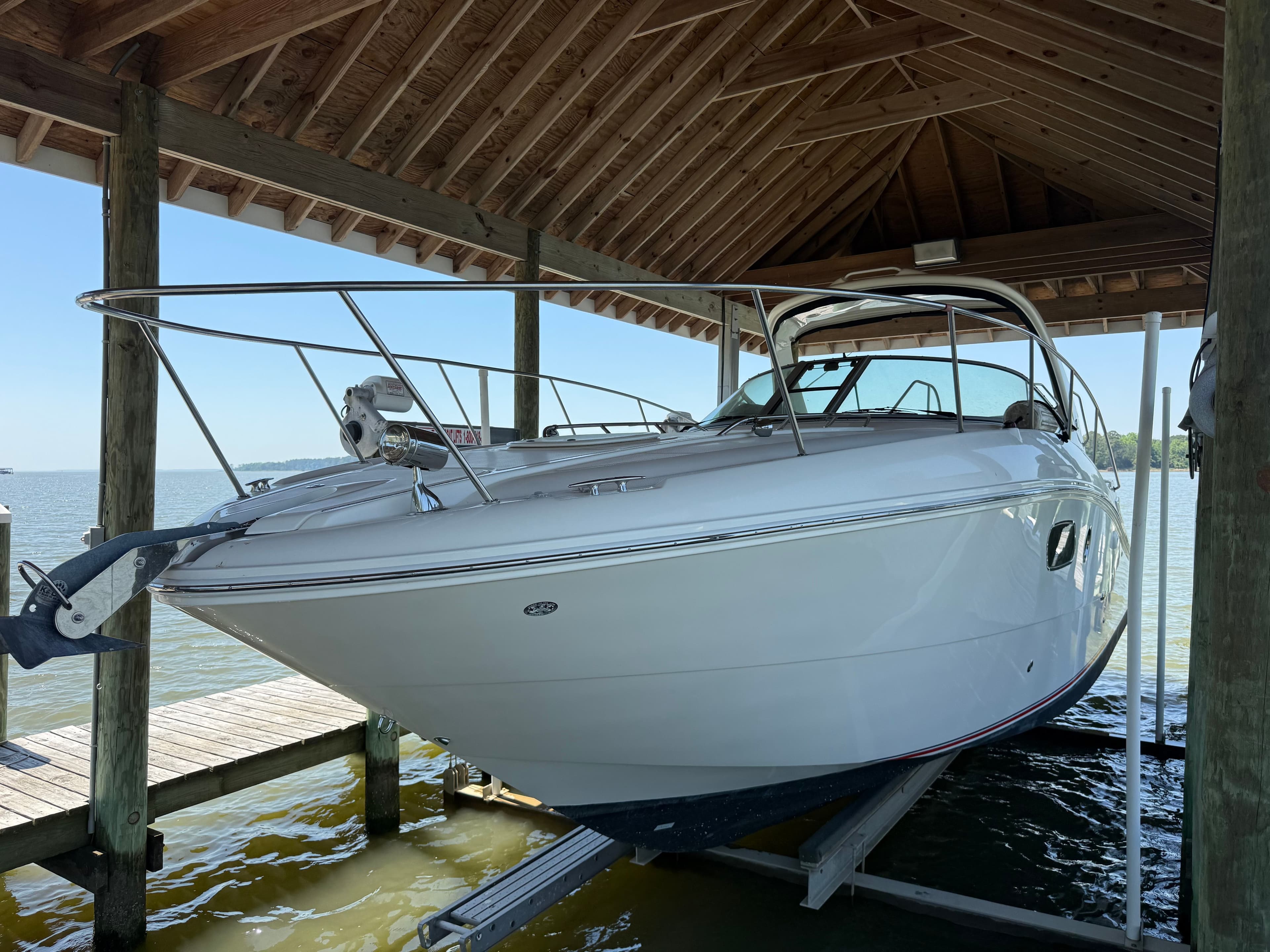 2012 Sea Ray Sundancer 350 under a wooden shelter by the water.