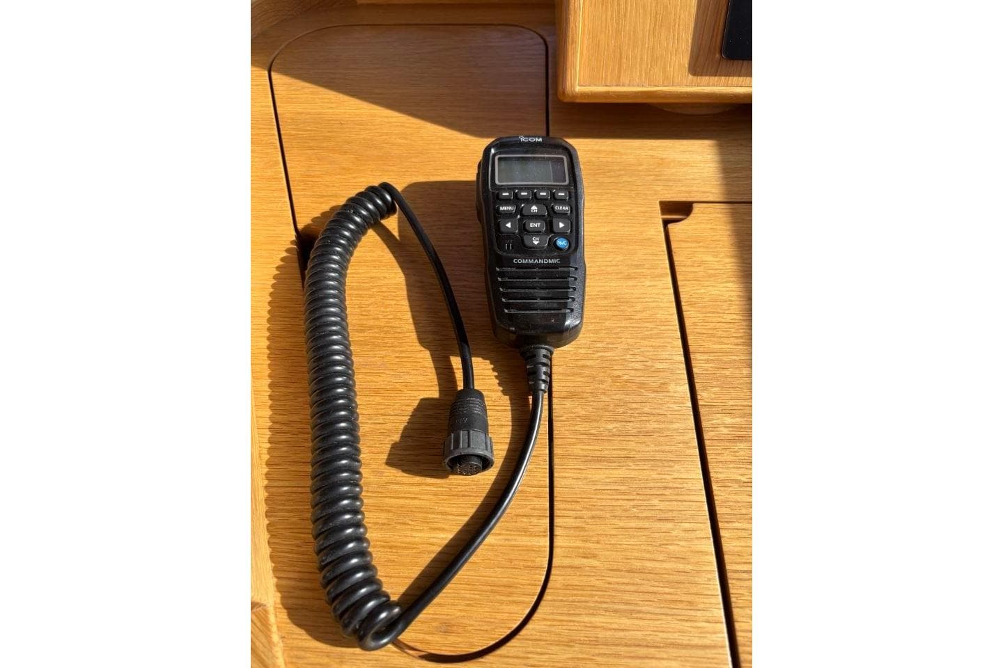 Handheld radio microphone on wooden surface, Discovery 58 yacht, 2021 model.