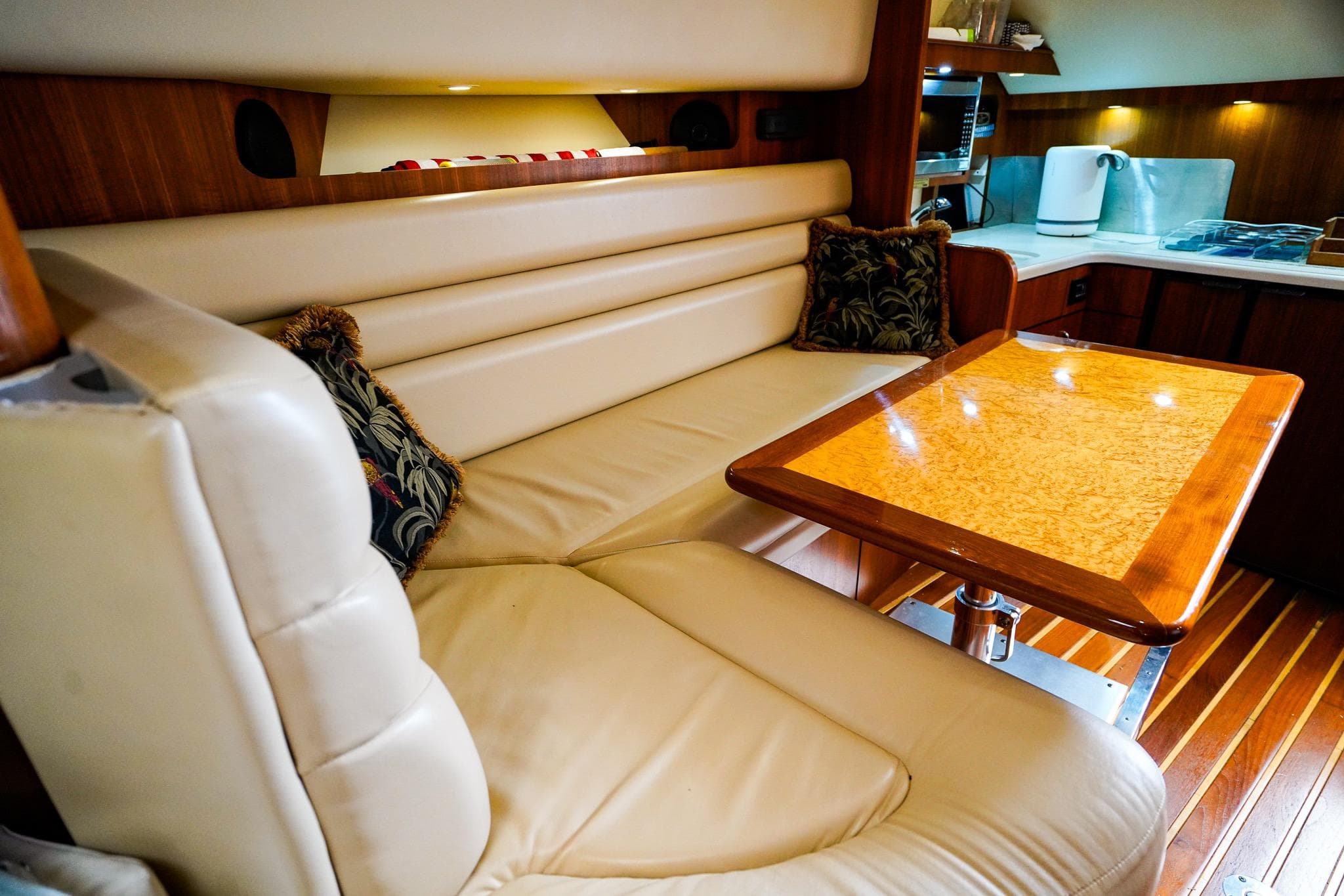 Luxurious interior of 2005 Tiara Yachts 3800 Open with leather seating and wooden table.