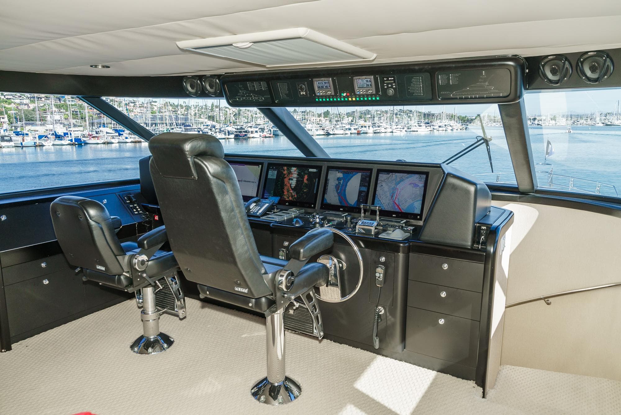 Bridge interior of 1992 Barattucci Yacht Fisher with navigation equipment and leather chairs.