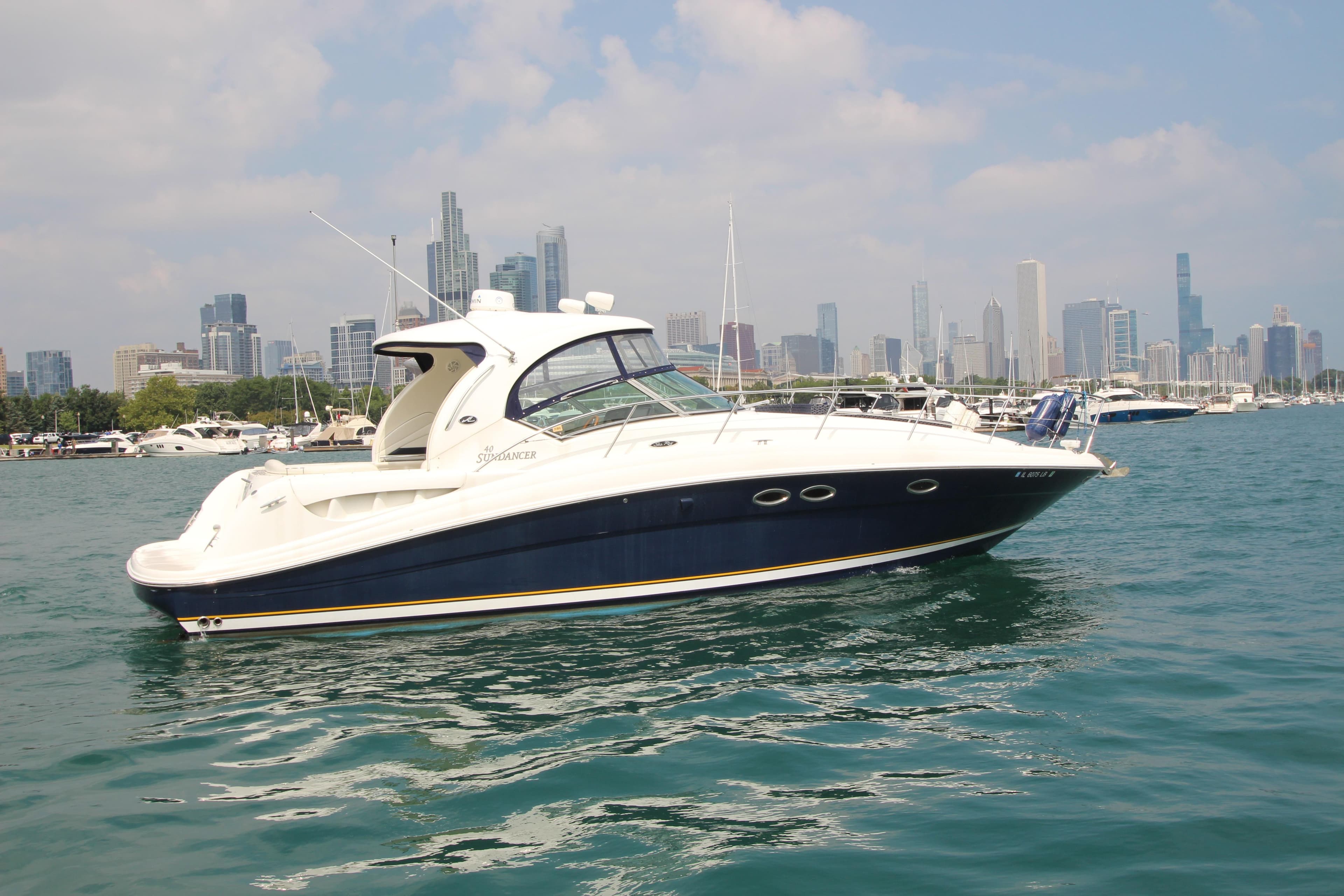 2004 Sea Ray 40 Sundancer yacht on water with city skyline in background.