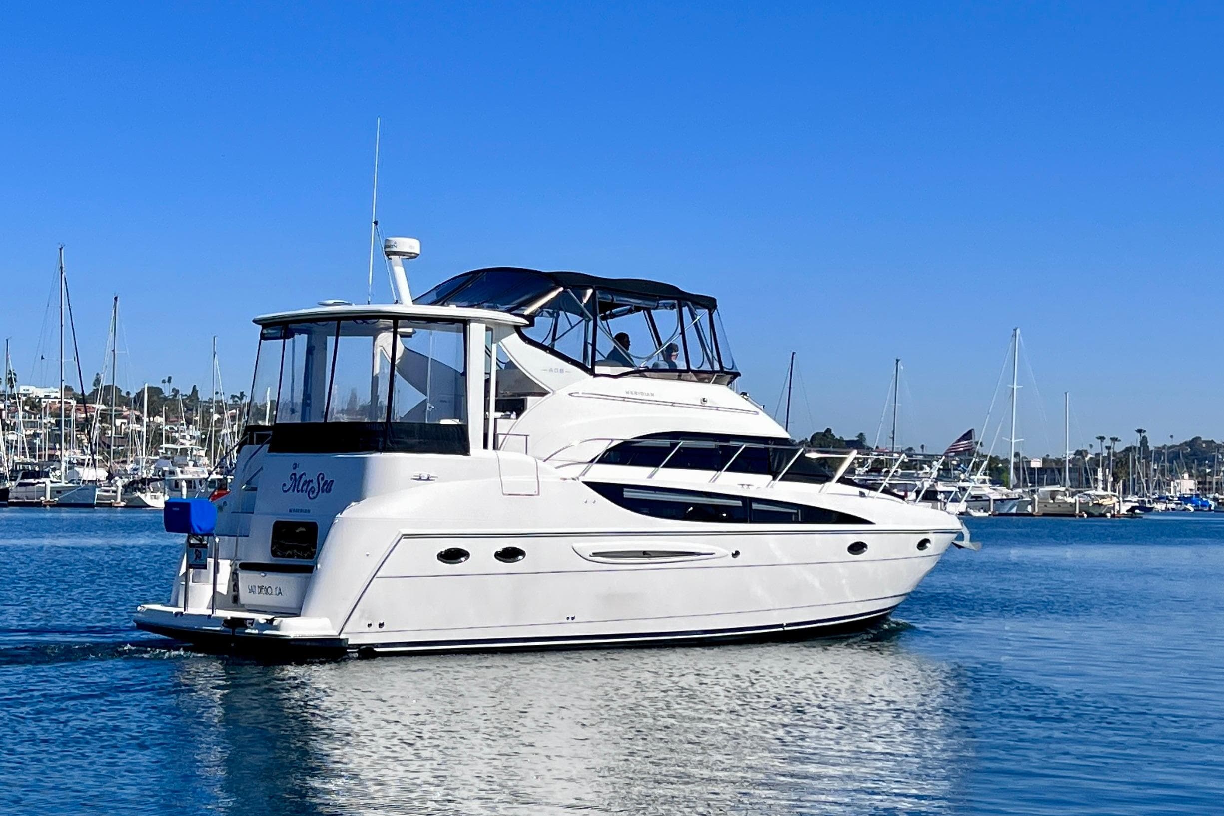 2004 Meridian 408 Motoryacht cruising in a marina under clear blue skies.