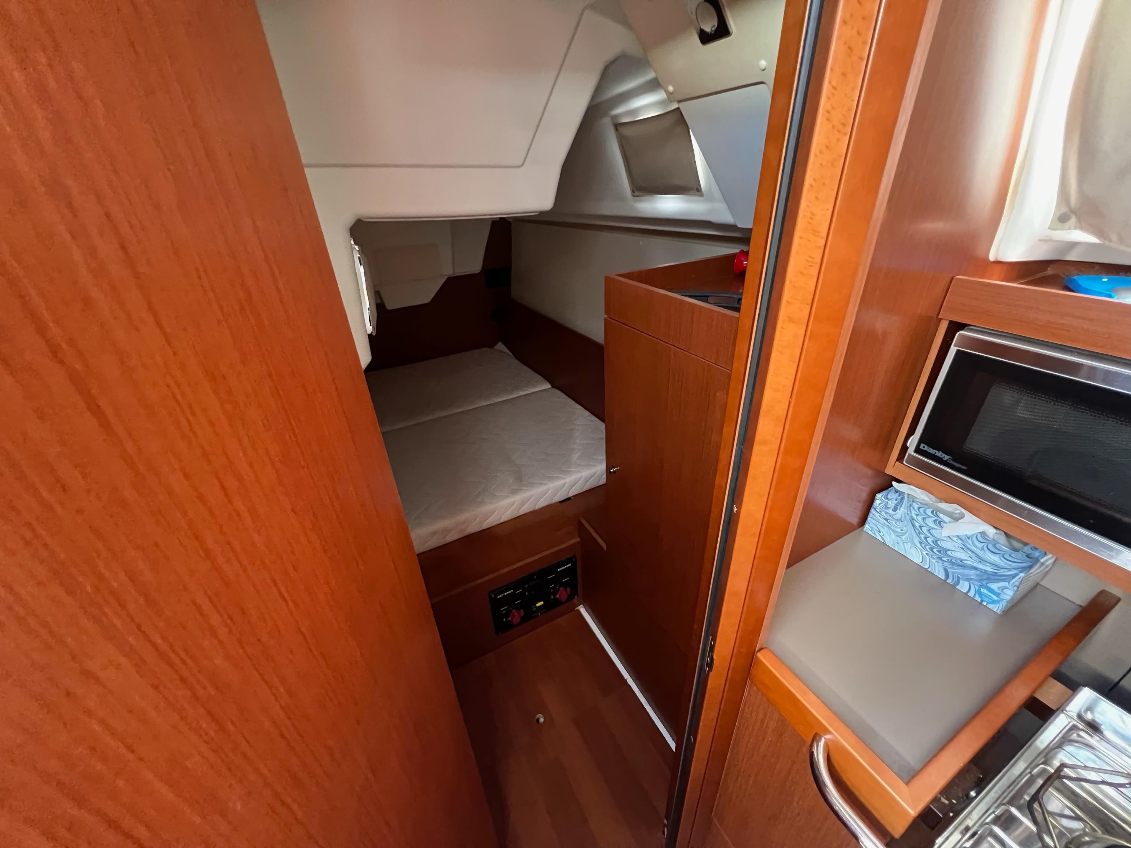 Interior cabin of 2019 Beneteau Oceanis 35.1 sailboat with wood finish and compact amenities.