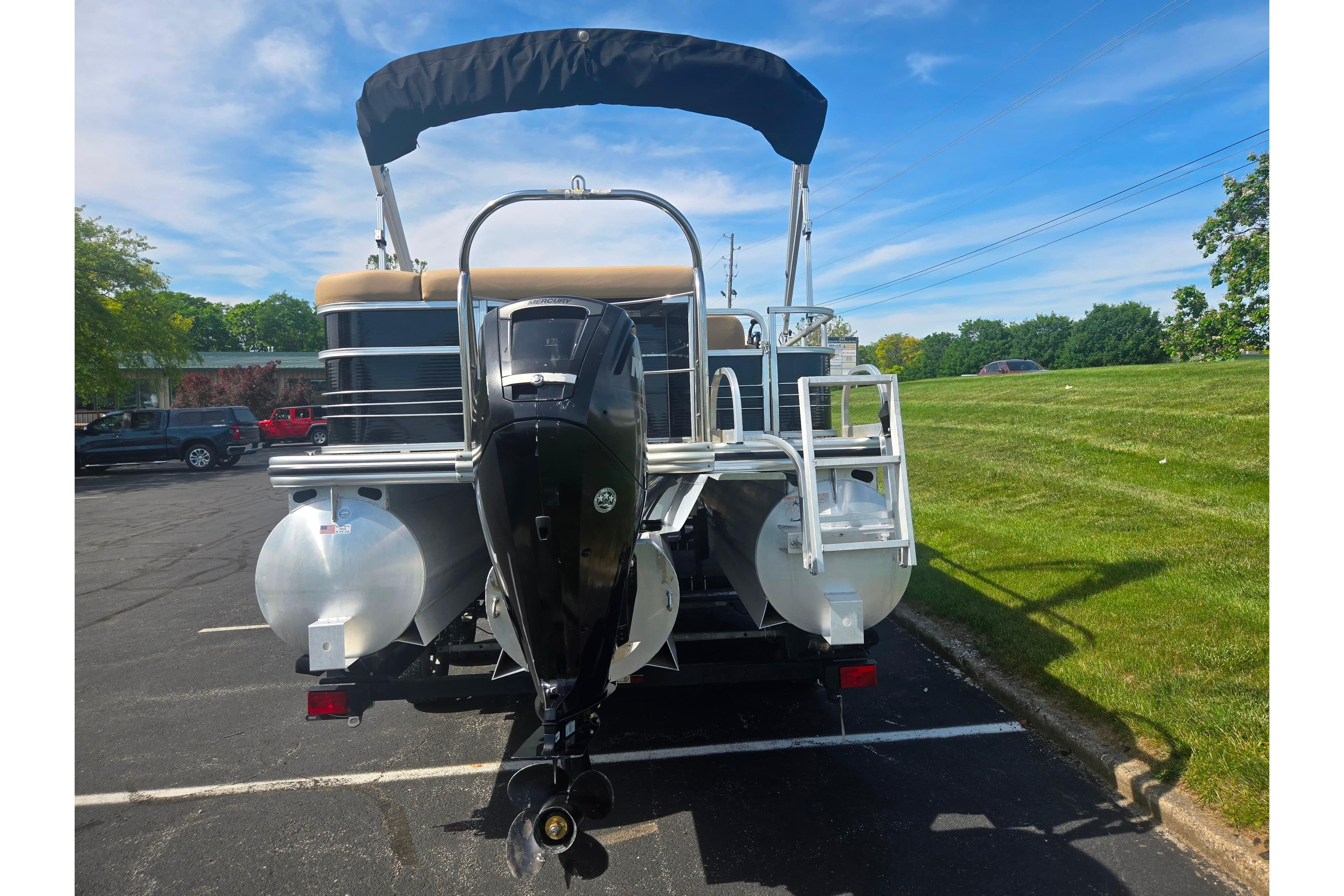 2017 Lowe SS 250 pontoon boat with outboard motor, parked on asphalt near grassy area.