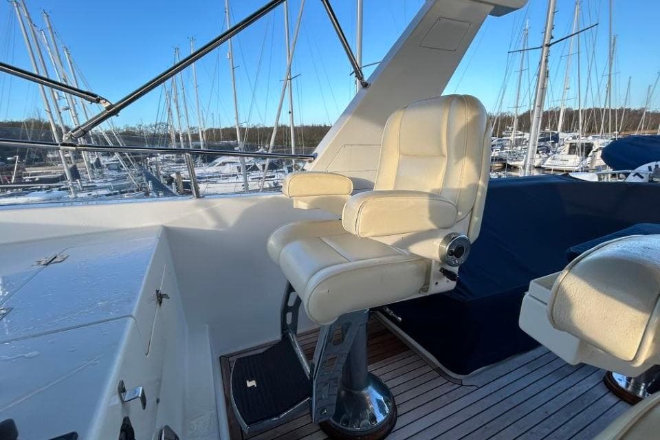 Captain's chair on 2008 Grand Banks 59 Aleutian RP yacht, docked in marina.