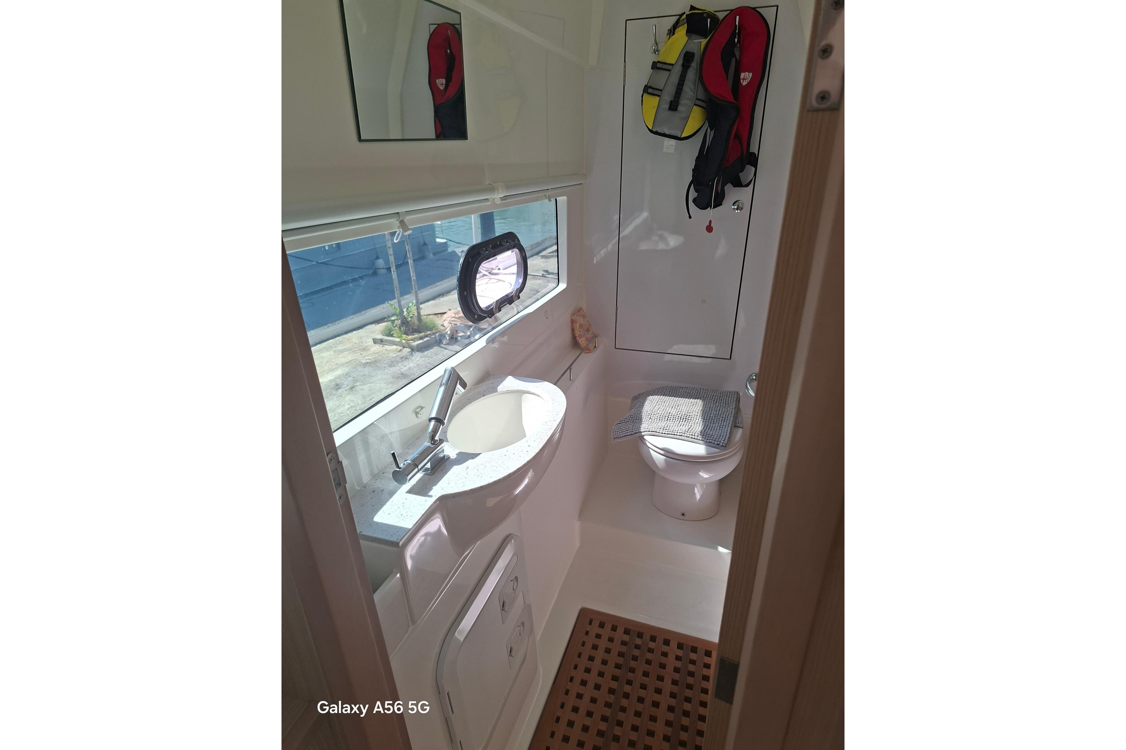 Bathroom interior of 2021 Aquila 36 Sport yacht, featuring sink, toilet, and window.