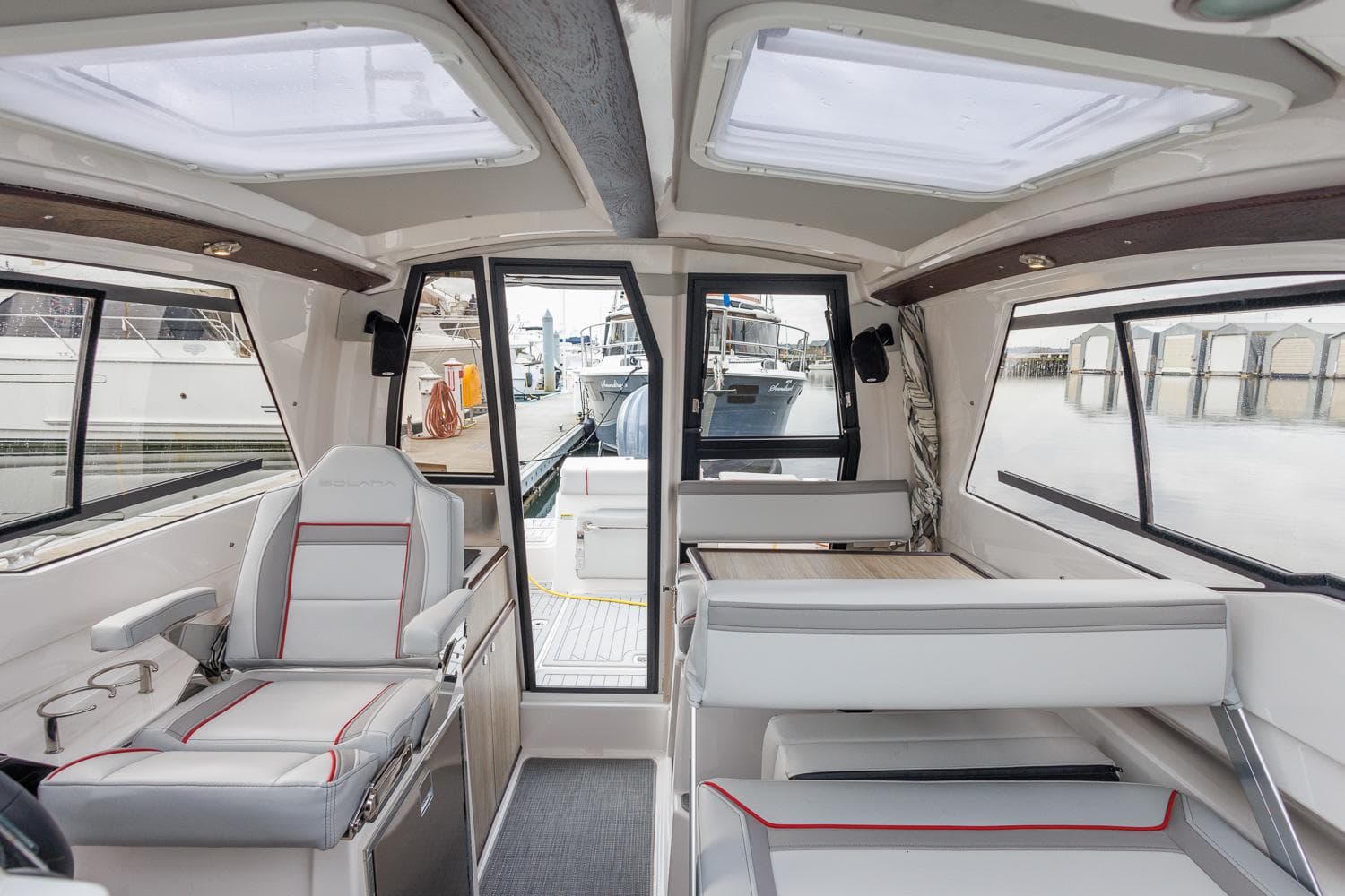 Interior of 2025 Solara S-250 Coupe boat, featuring modern seating and panoramic windows.