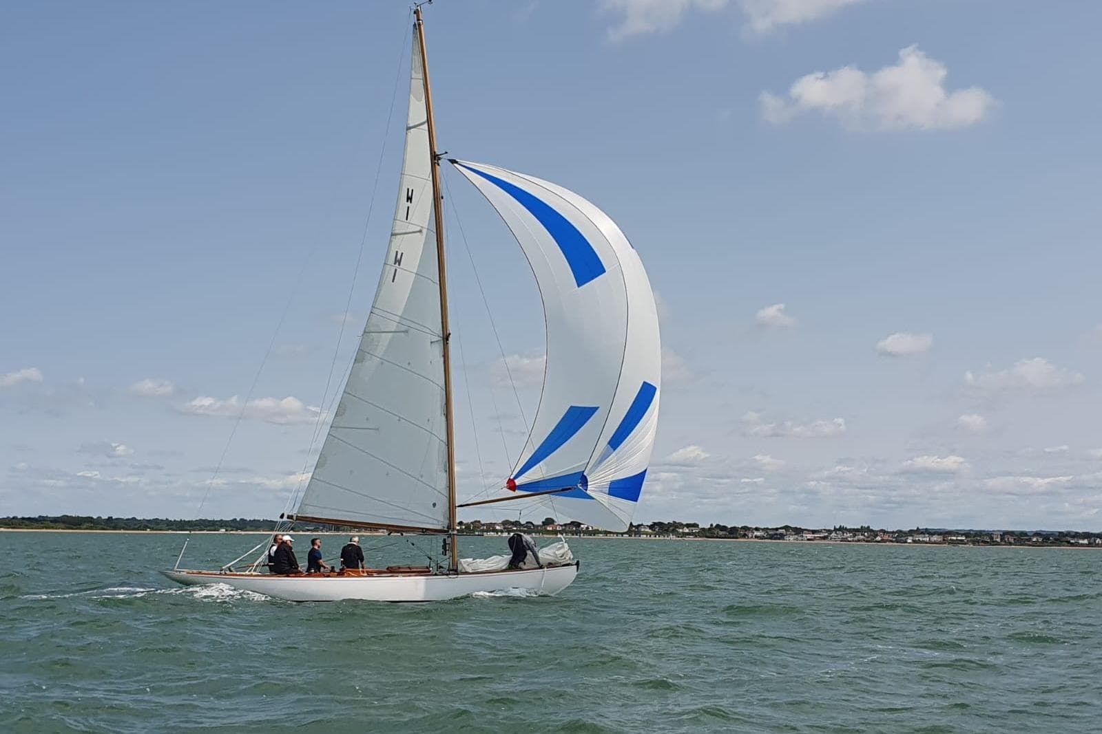 Classic 1924 West Solent One Design "ARROW" sailing with blue and white spinnaker.