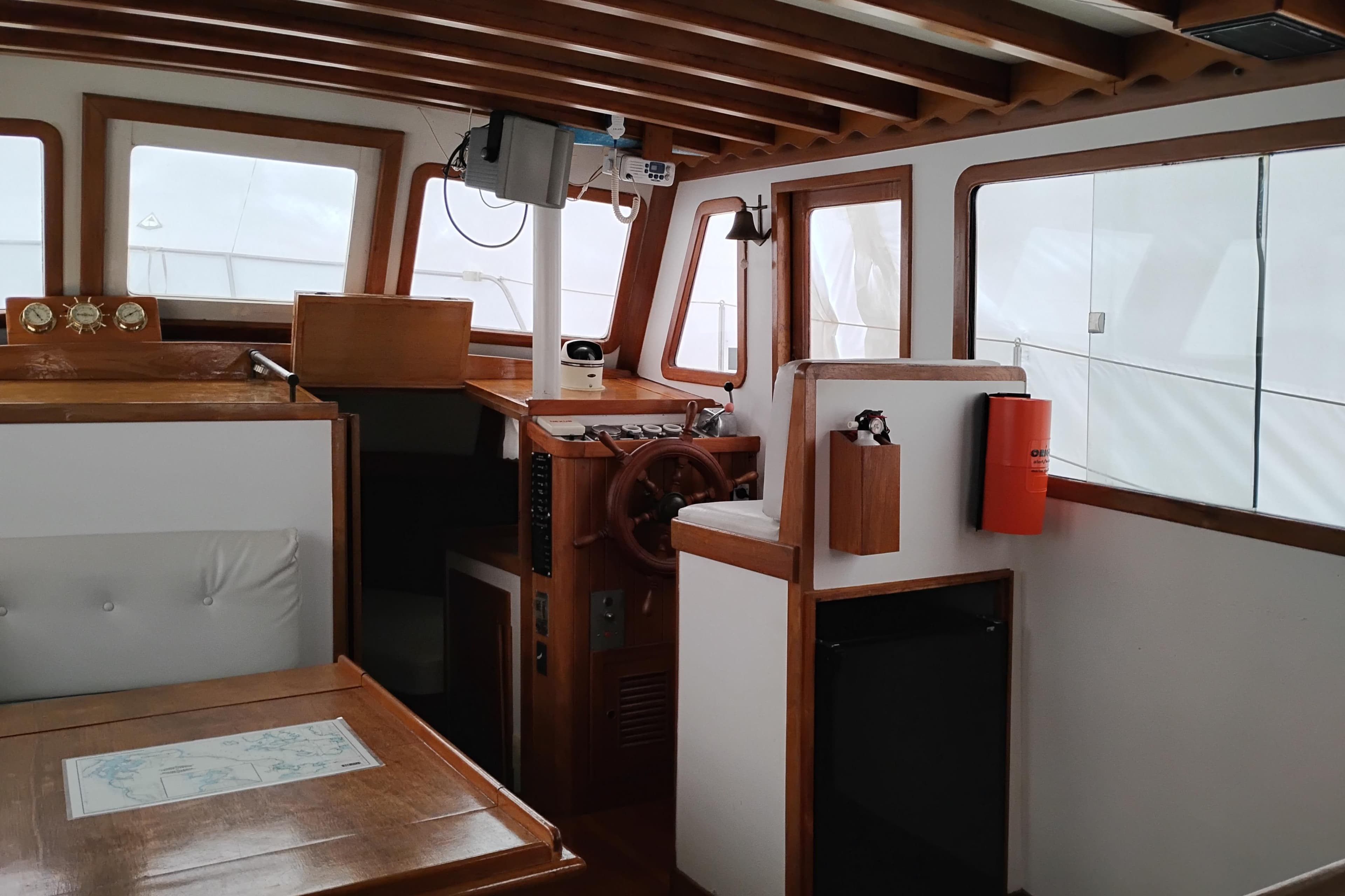 Interior of 1979 Transpac Eagle 36 Trawler with wooden helm and seating area.