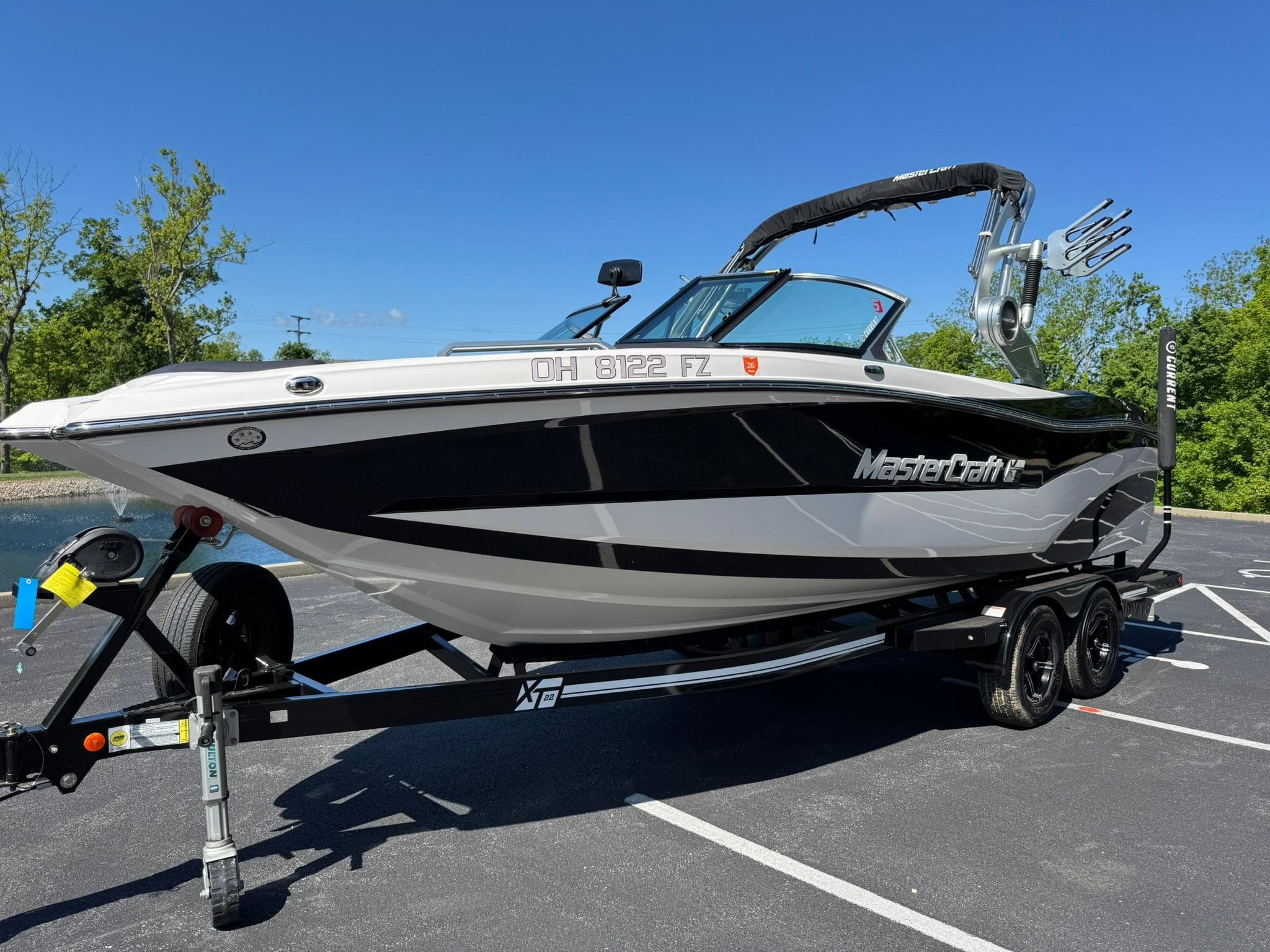 2020 MasterCraft XT22 boat on trailer in parking lot, sunny day.