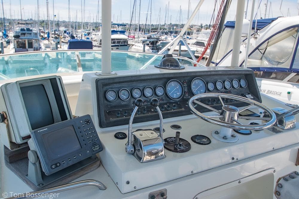 Control panel of a 1986 Bertram 42 Convertible yacht in a marina setting.