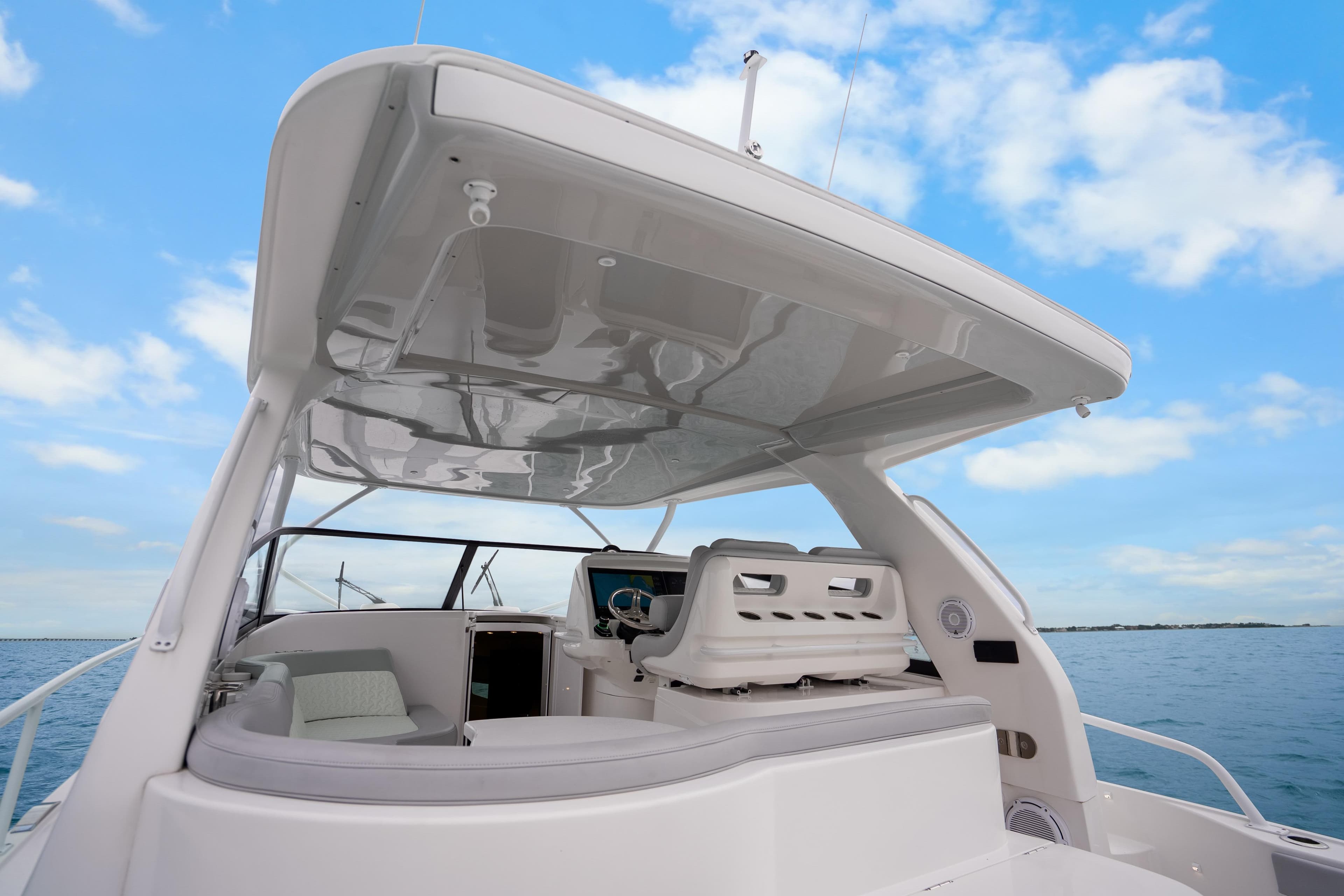 2024 Intrepid 477 Evolution yacht with sleek design and spacious deck under blue sky.
