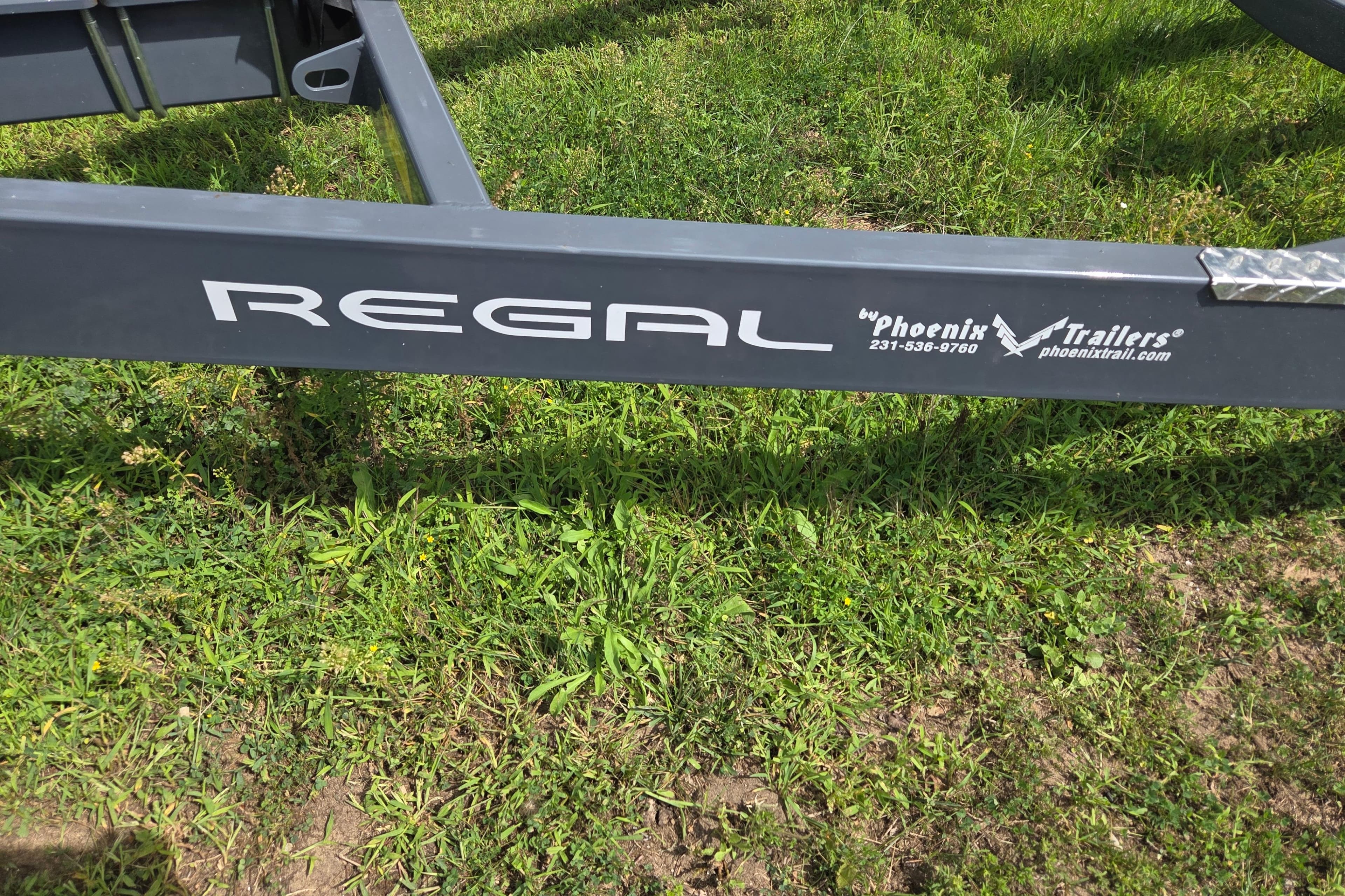 Trailer frame for 2021 Regal 26 Express by Phoenix Trailers on grass.