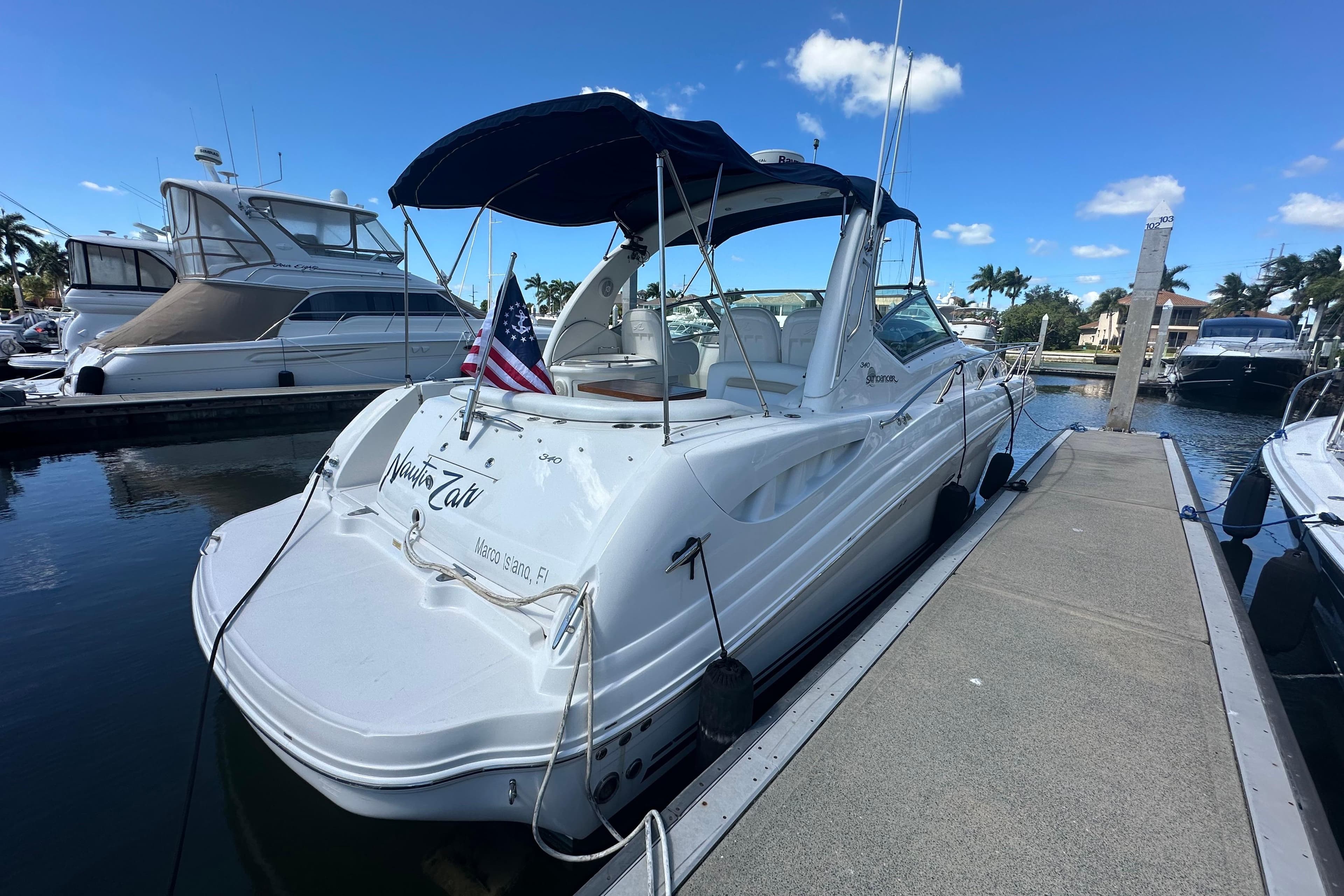 2008 Sea Ray 340 Sundancer docked at marina, clear sky, American flag displayed.