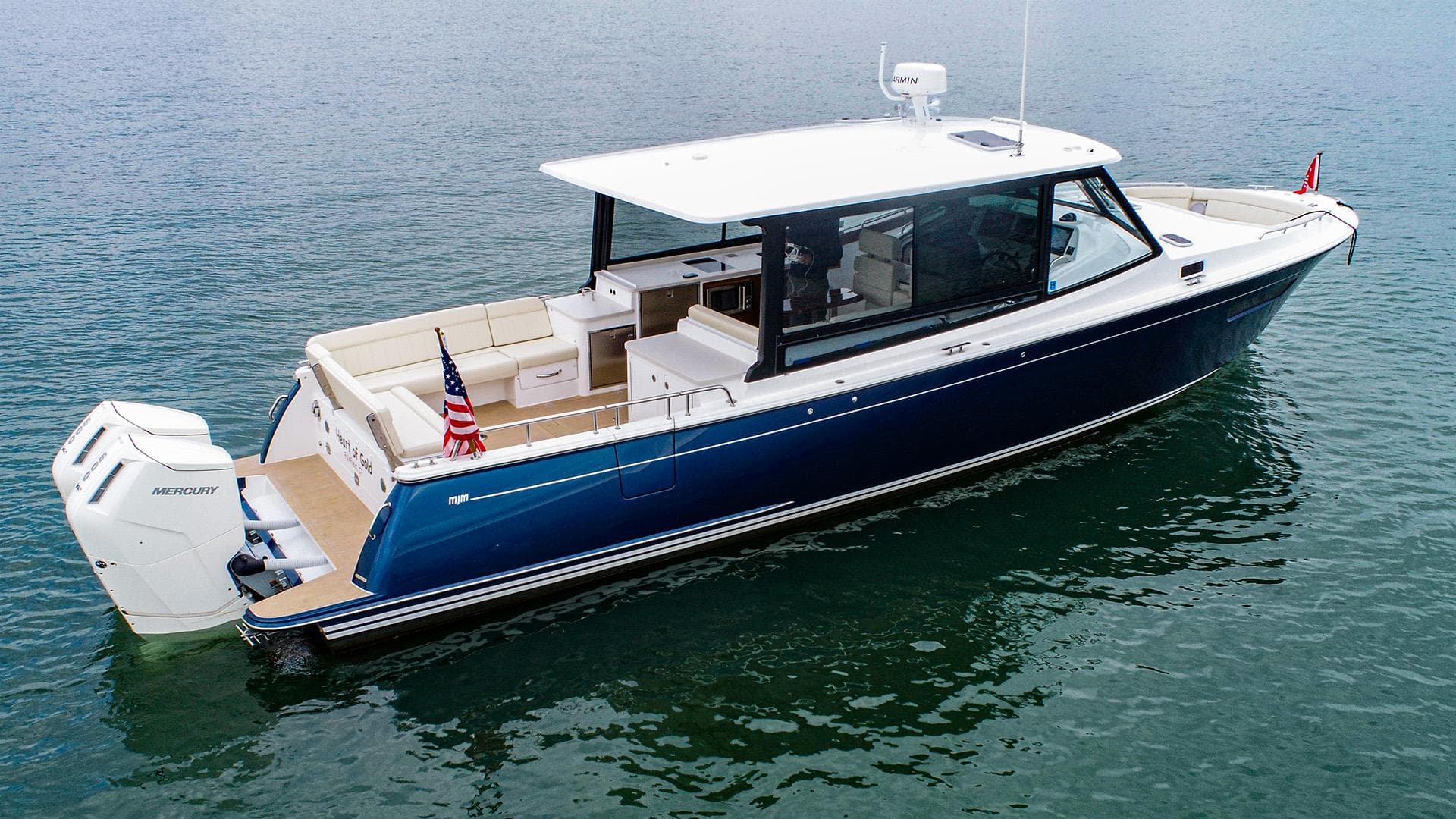 2024 MJM 4 boat on water, sleek design, blue hull, outboard motor.
