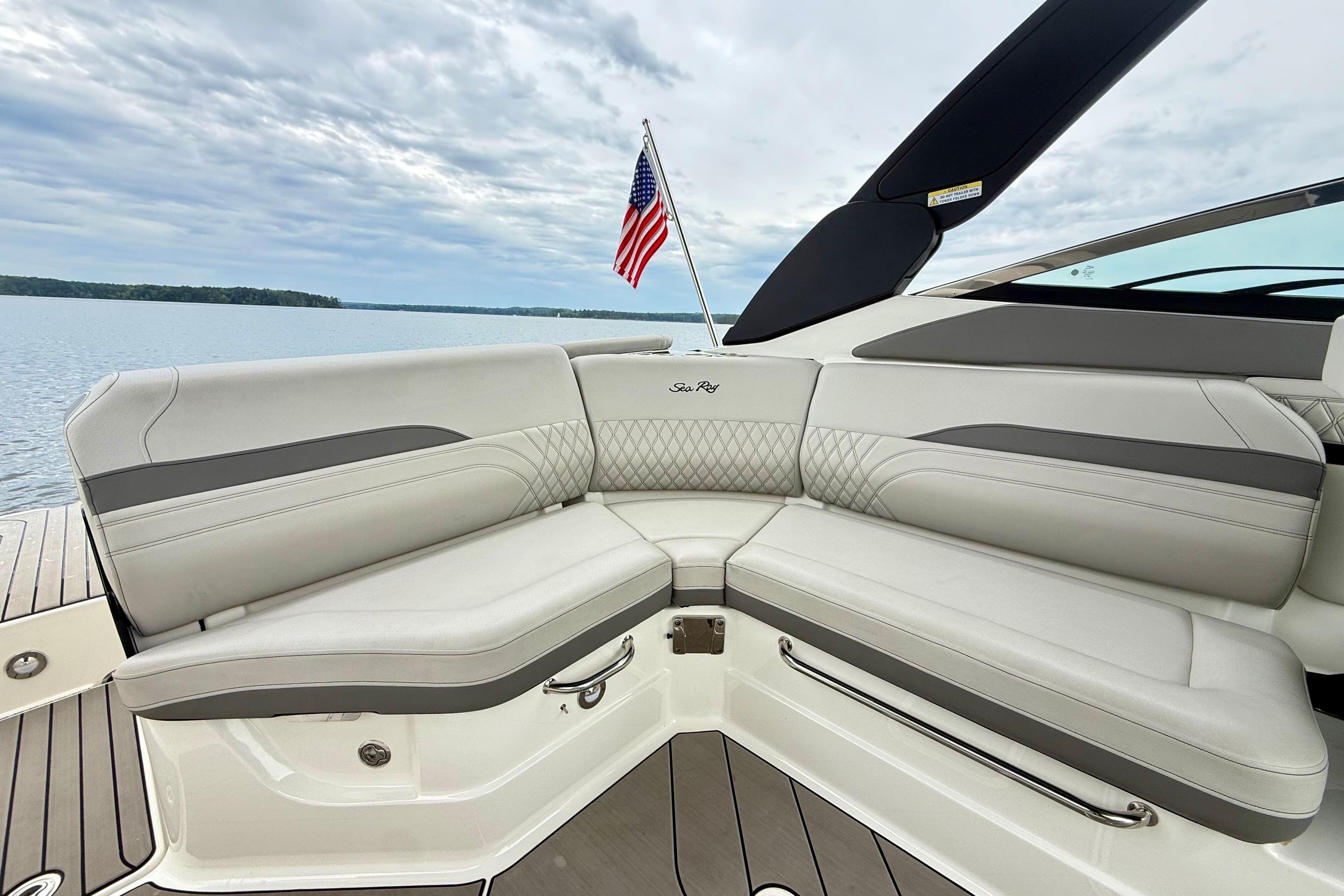 Luxurious seating on 2023 Sea Ray SLX 260 boat with American flag in background.