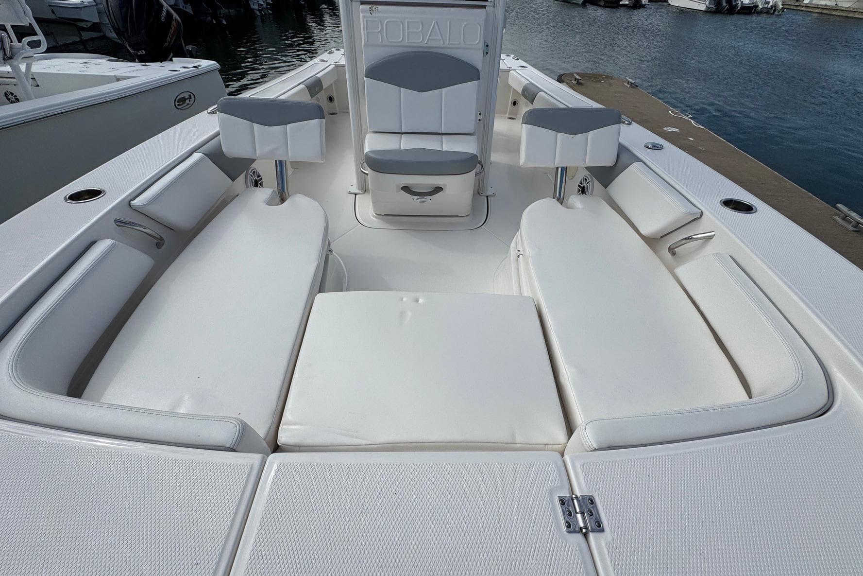 2021 Robalo 246 Cayman boat interior with white cushioned seating at the dock.