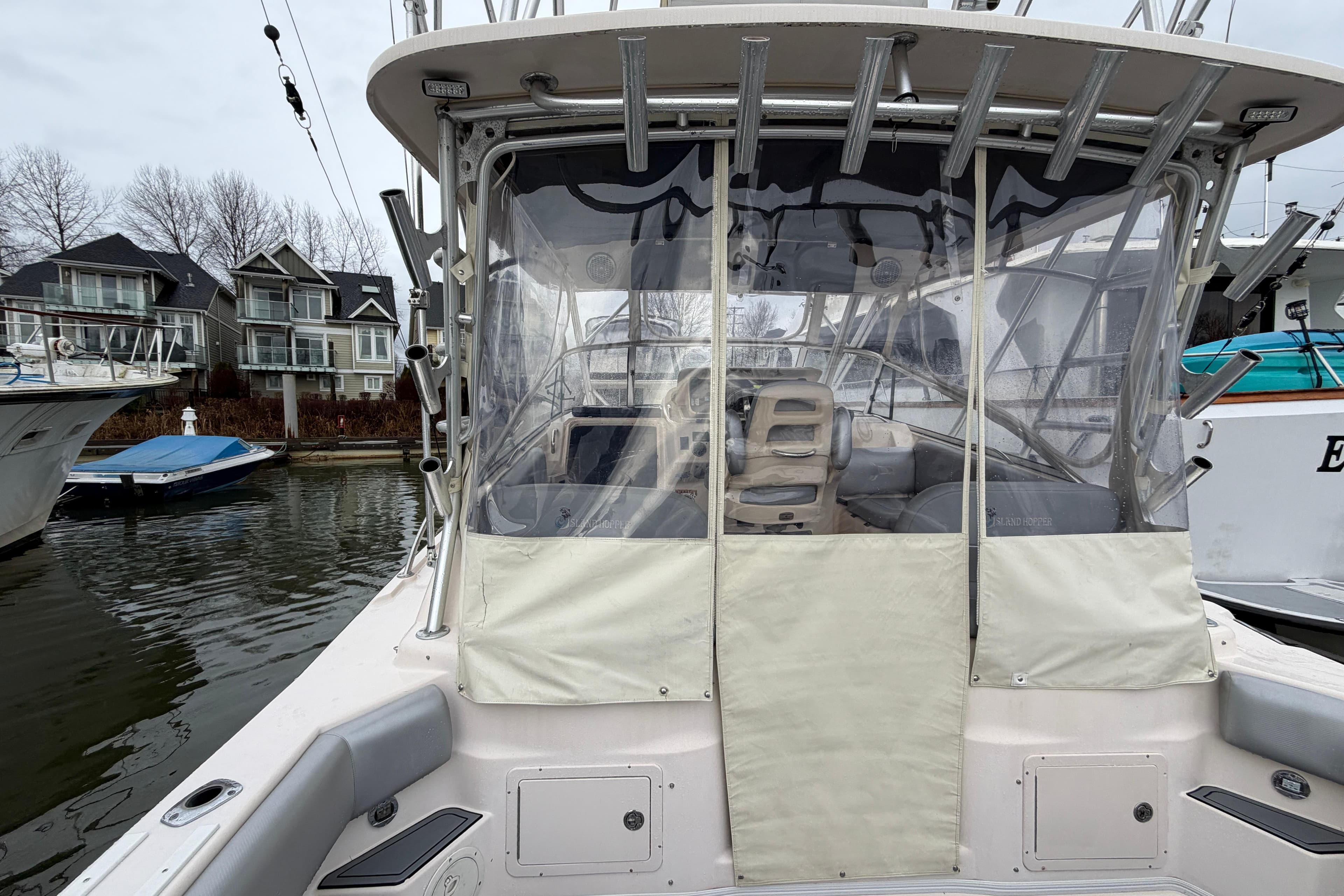 2004 Grady-White Express 330 boat docked, featuring covered cockpit and waterfront homes in background.