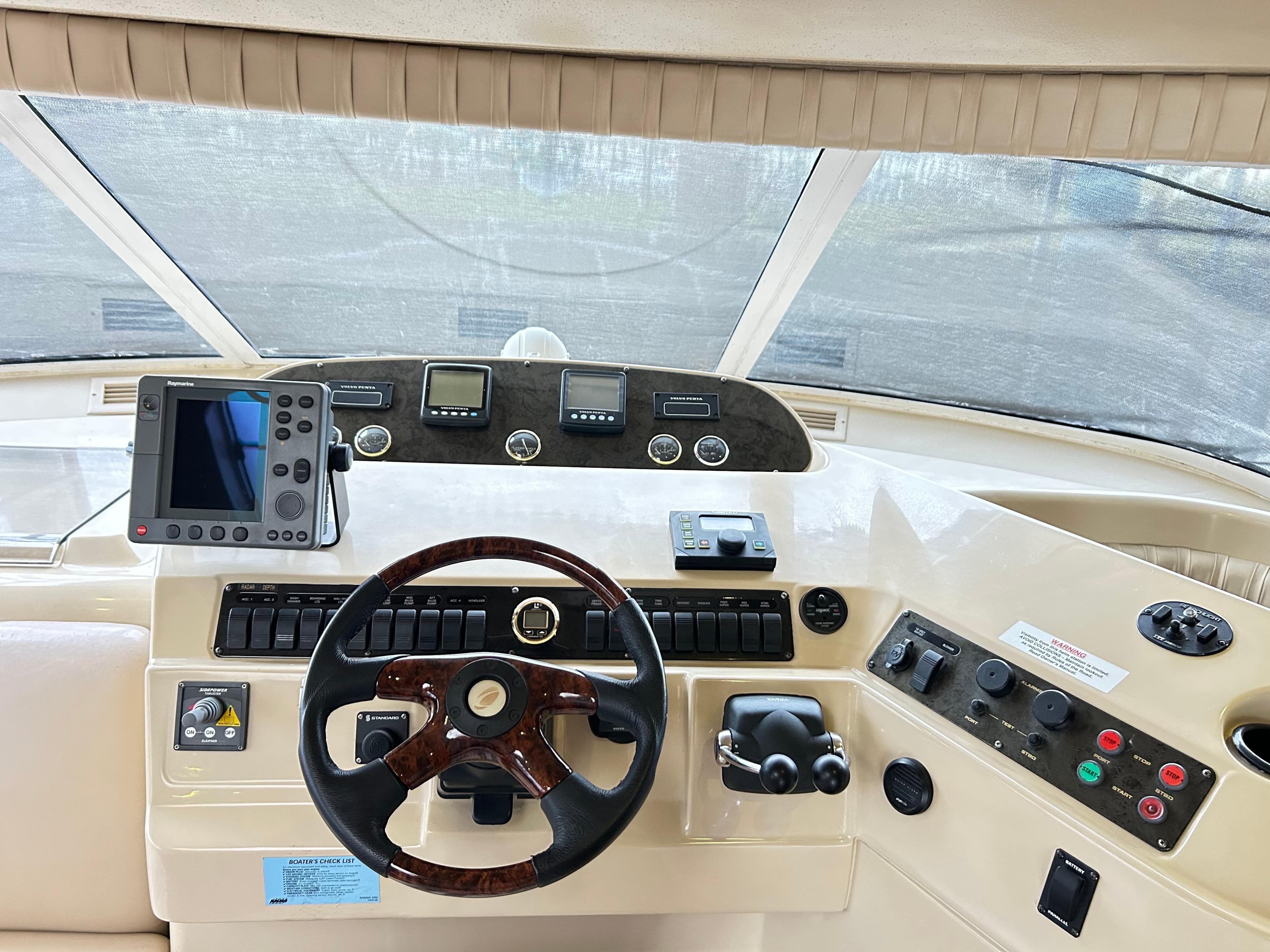 2004 Cruisers Yachts 5000 Sedan Sport helm with steering wheel and navigation controls.