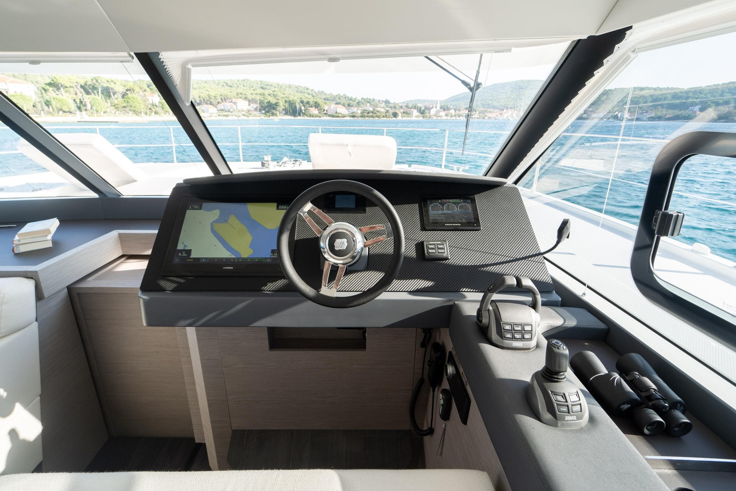Helm of 2023 Fountaine Pajot MY 6 yacht with navigation equipment and scenic ocean view.