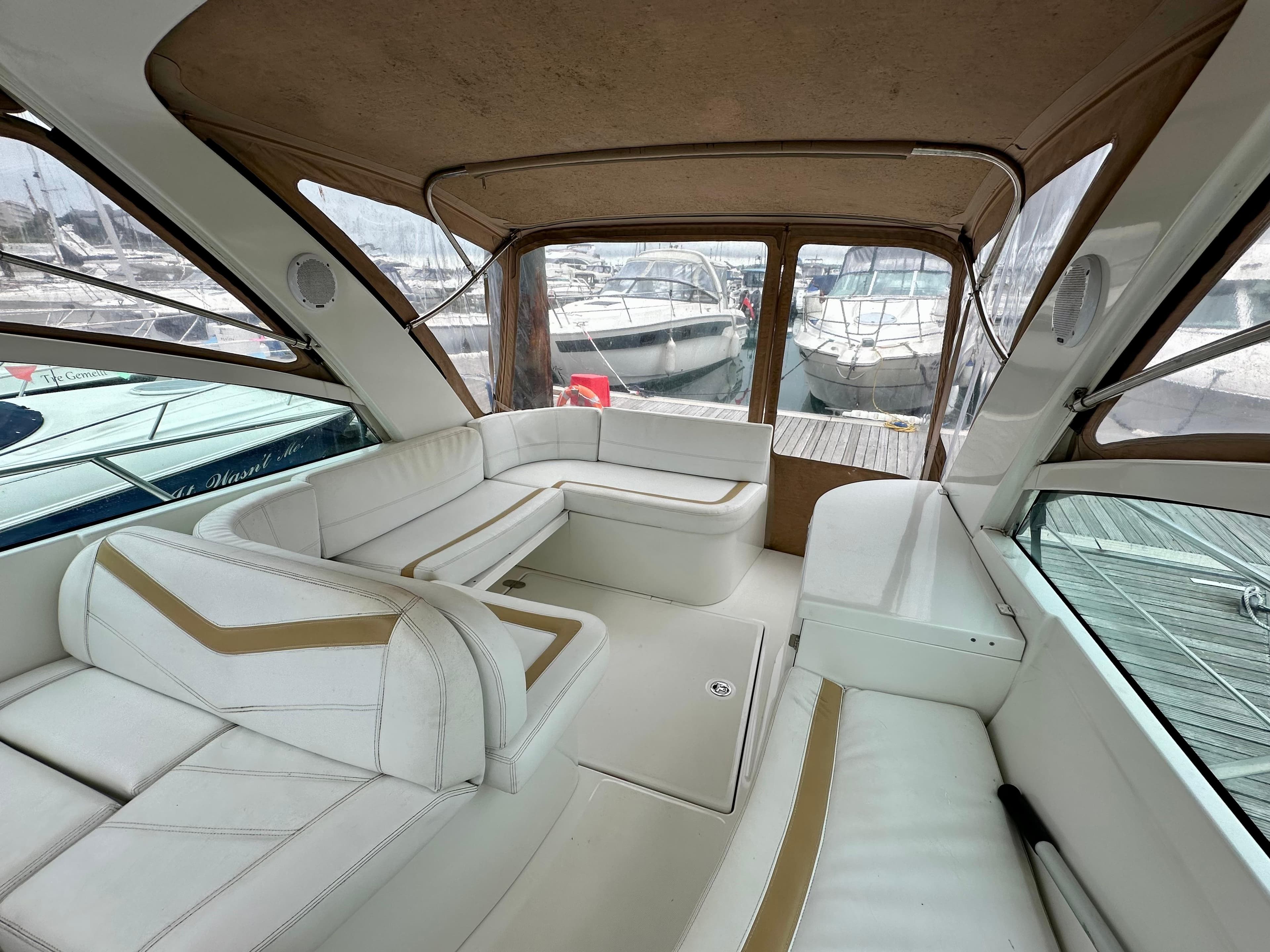 Interior of 2011 Starfisher Cancun 260 boat with white seating and marina view.