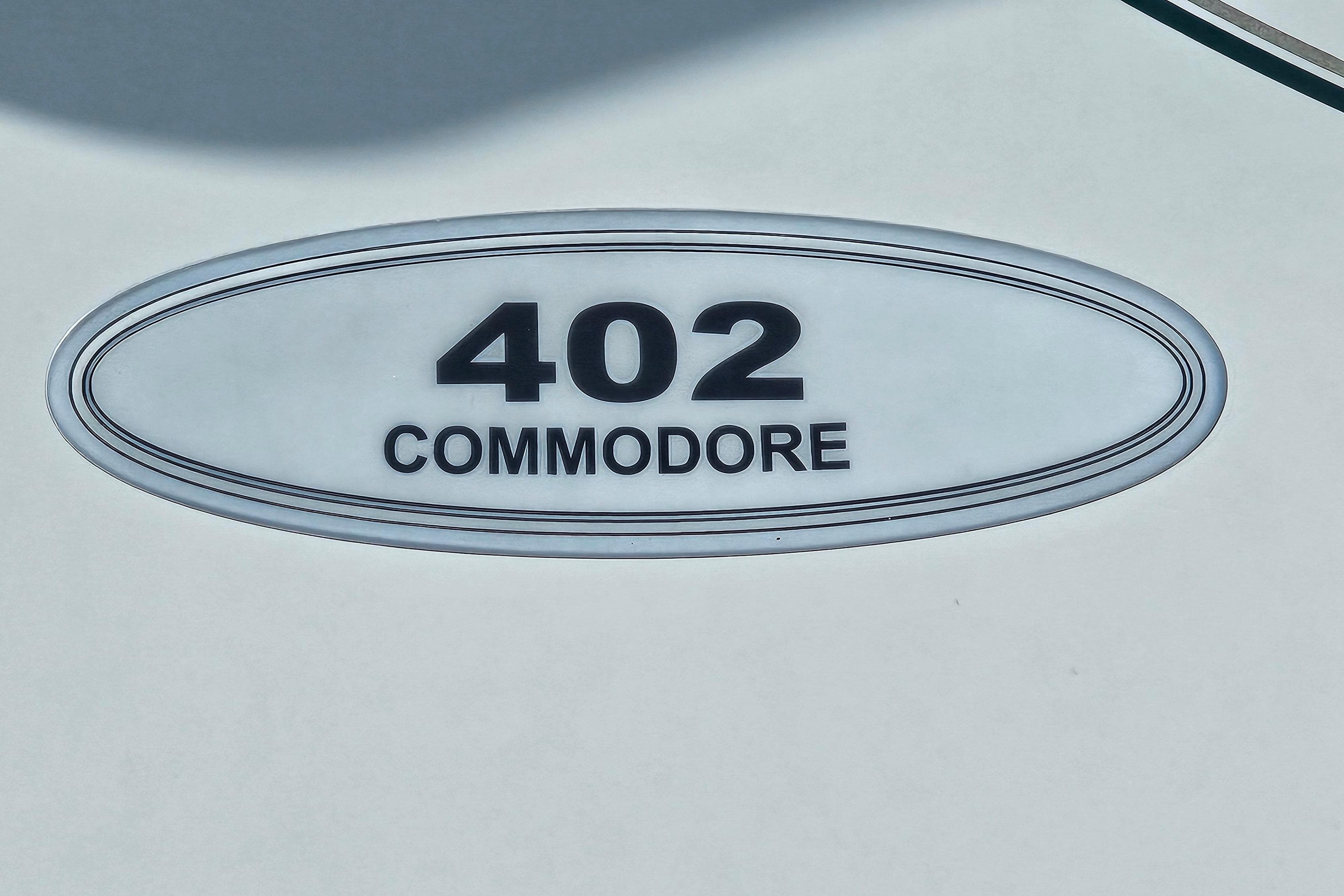 Regal Commodore 402 emblem, 1997 model, oval design with black text on white background.