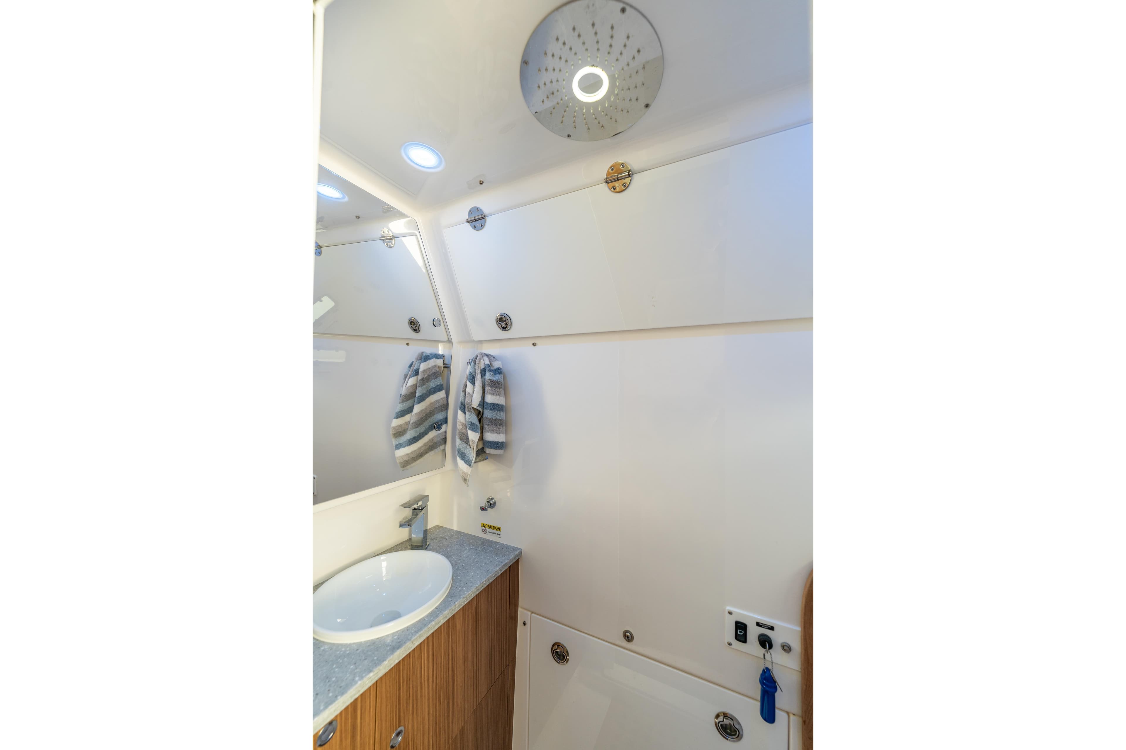 2021 Everglades 395 Center Console bathroom with modern sink and striped towels.