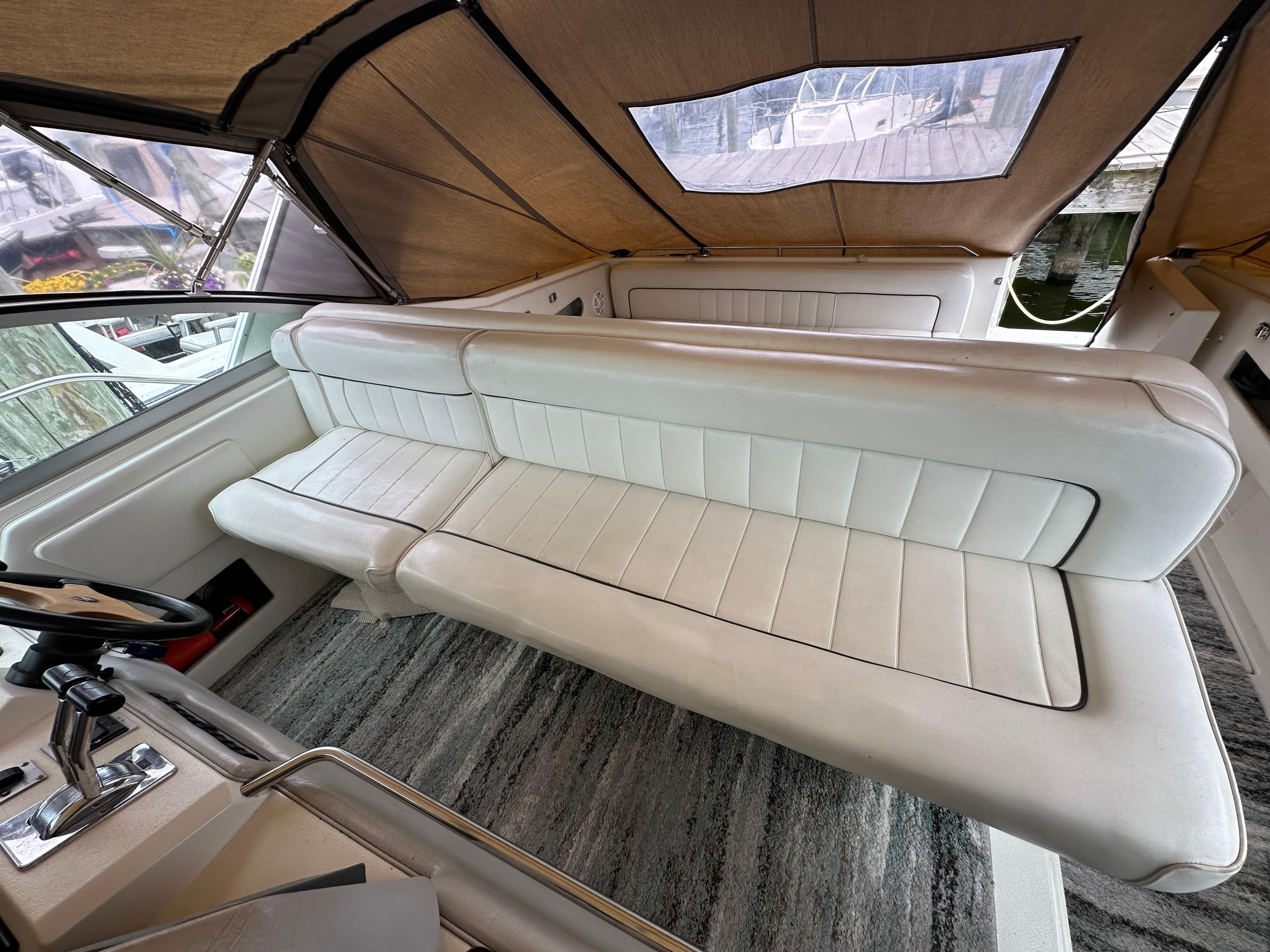 1994 Sea Ray 370 Sundancer interior with white leather seating and helm station.