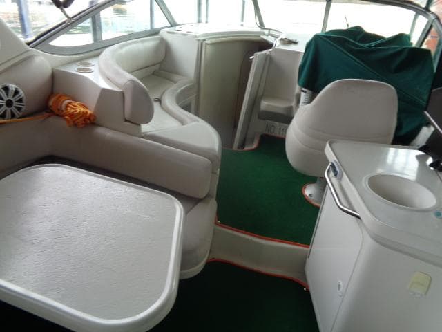 Interior of a 1997 Regal 292 Commodore boat with white seating and green carpet.