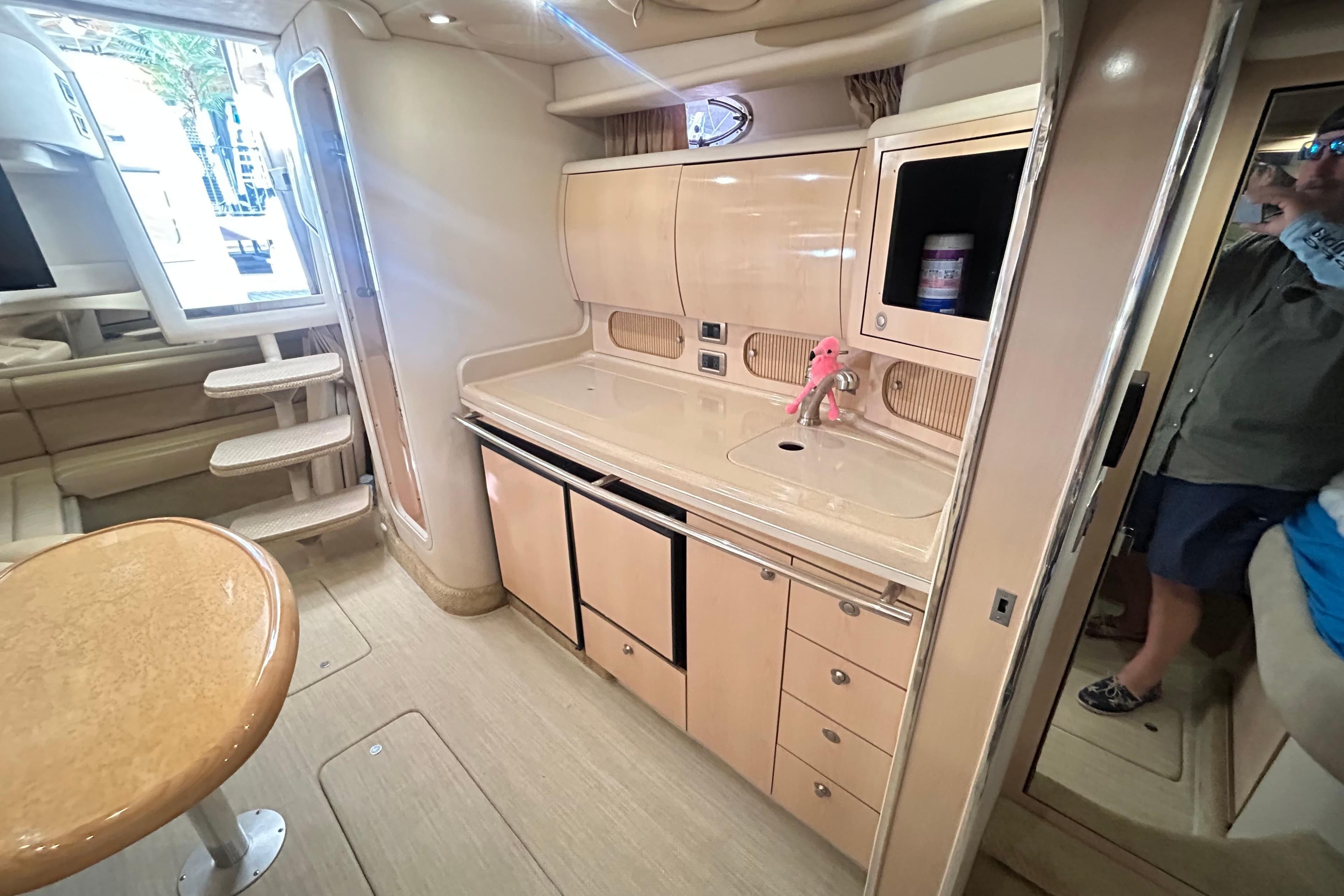 Interior of 2004 Sea Ray 360 Sundancer yacht with modern kitchen and seating area.