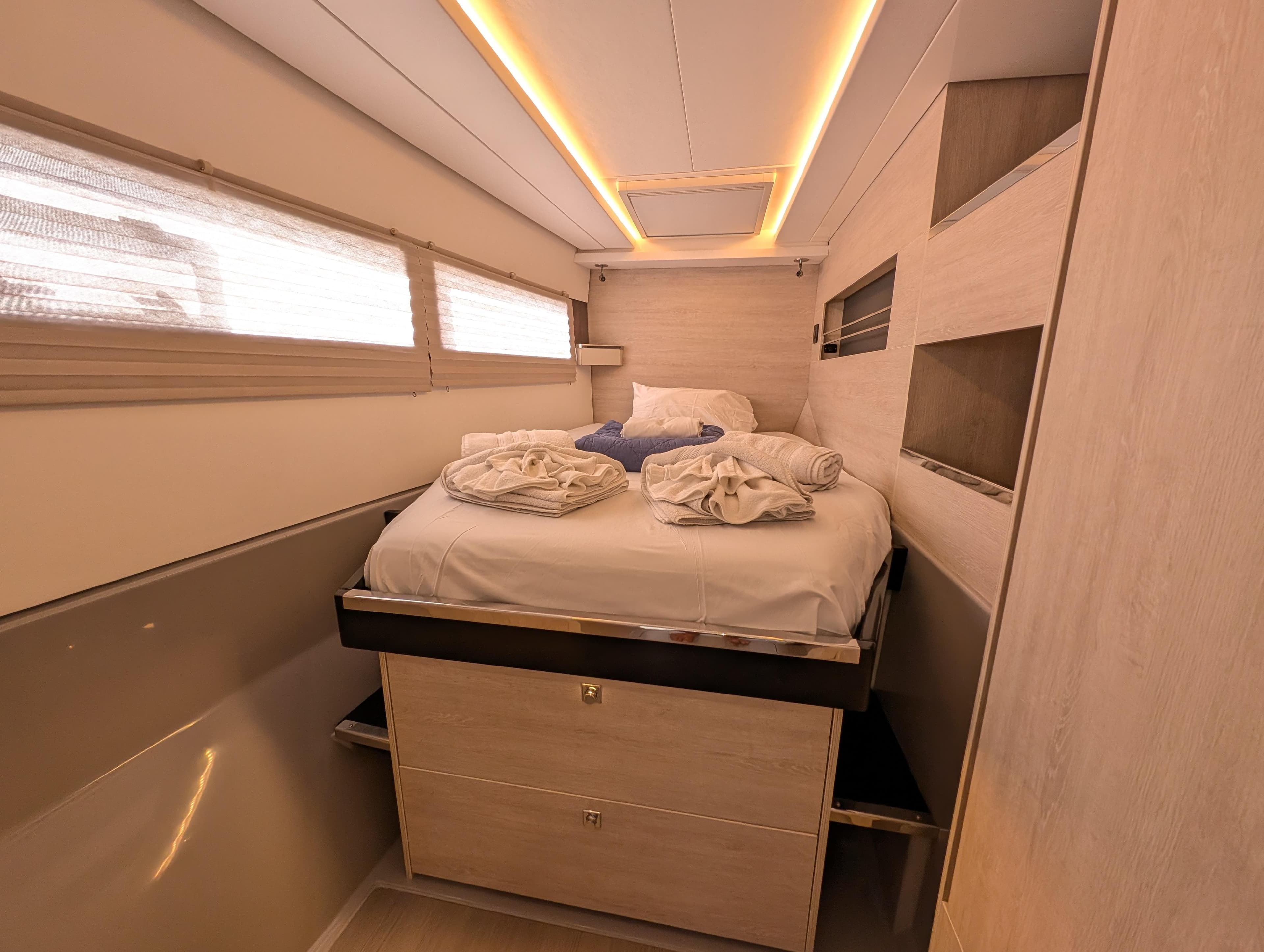 Luxurious cabin interior of a 2020 Leopard 45 yacht with cozy bedding and ambient lighting.