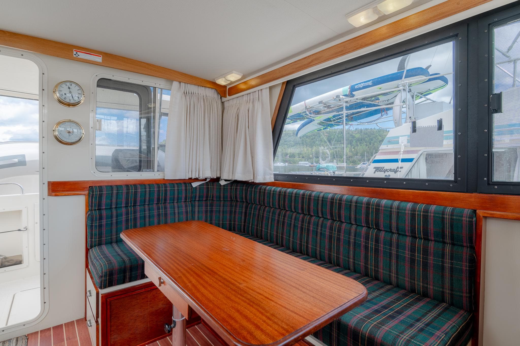 Interior of a 1996 Camano 31 with wooden table and cushioned seating.