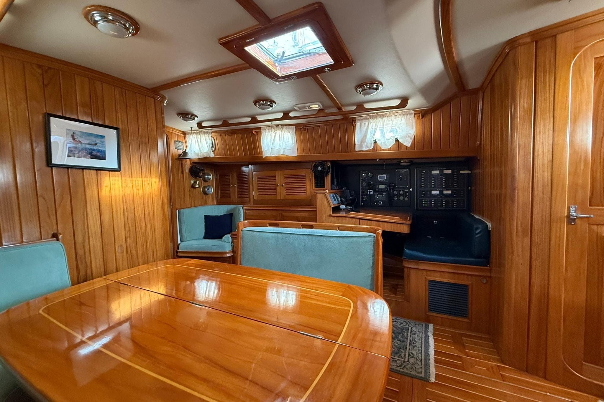 Luxurious interior of 2000 Cabo Rico Cutter 45 sailboat with wood paneling and seating.