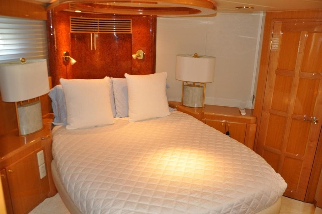 Luxurious bedroom in a 2003 McKinna 58 yacht with elegant wood finishes.