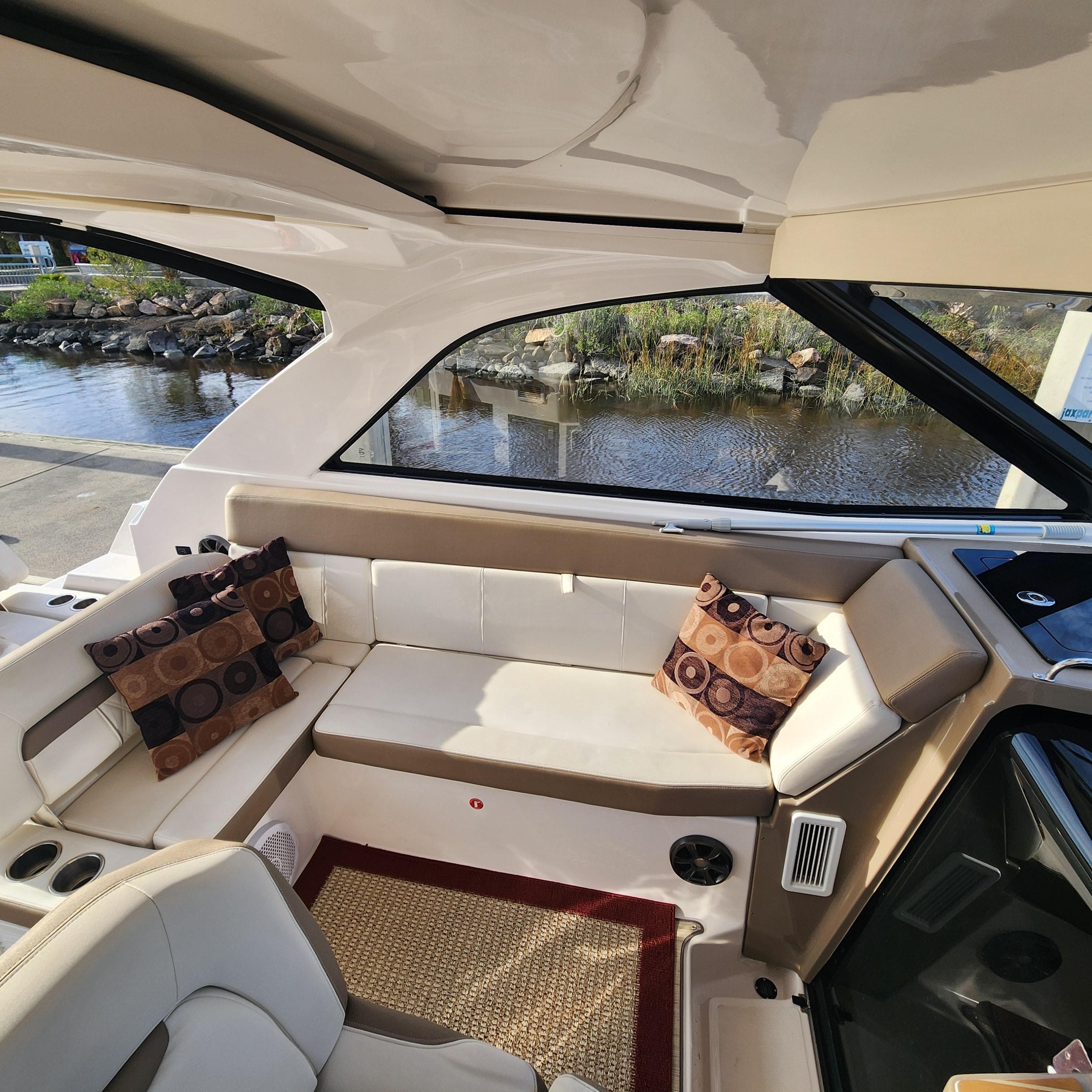 Interior of 2018 Regal 35 Sport Coupe with white seating and decorative pillows.