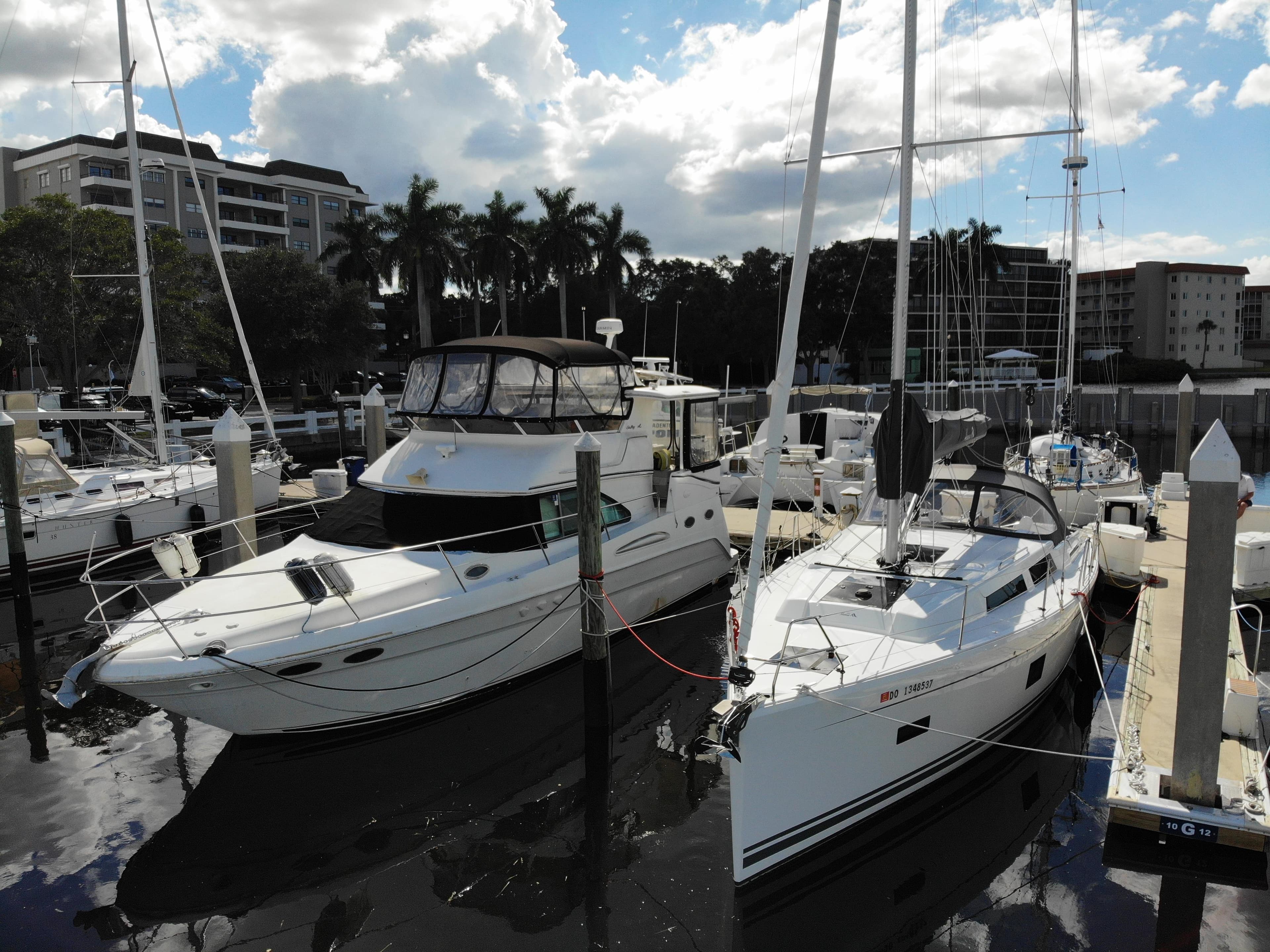 2024 Hanse 388 yacht docked at marina, surrounded by other boats and palm trees.