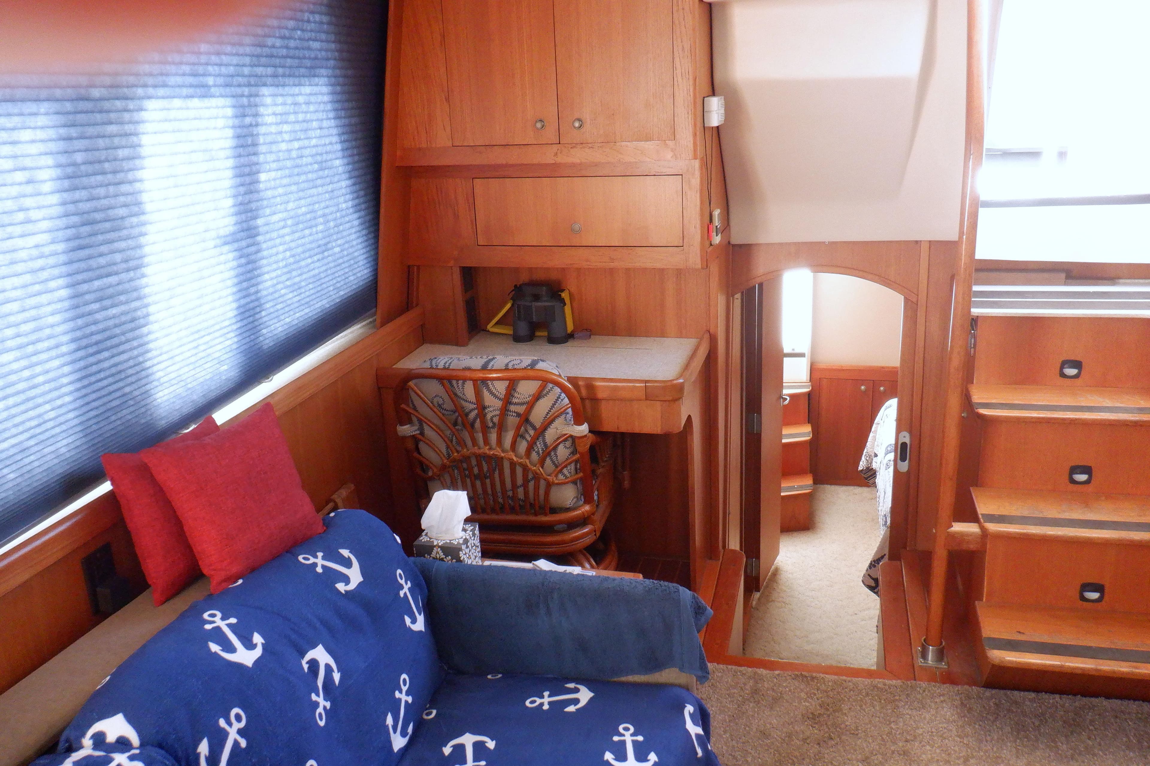 Interior of 2002 Mainship 430 Trawler with nautical-themed decor and wooden furnishings.
