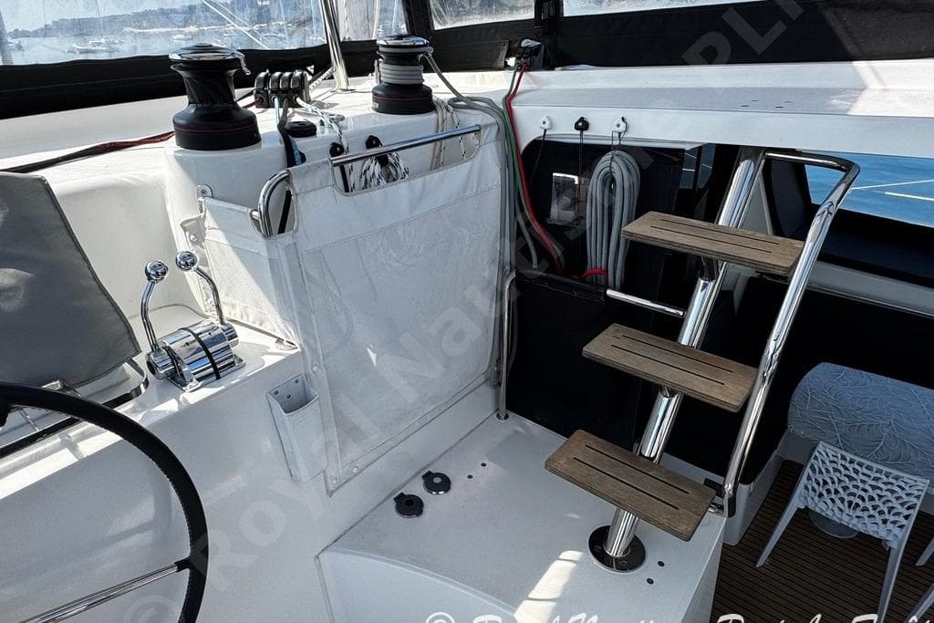 Cockpit of 2018 Lagoon 42 catamaran with helm, winches, and wooden steps.