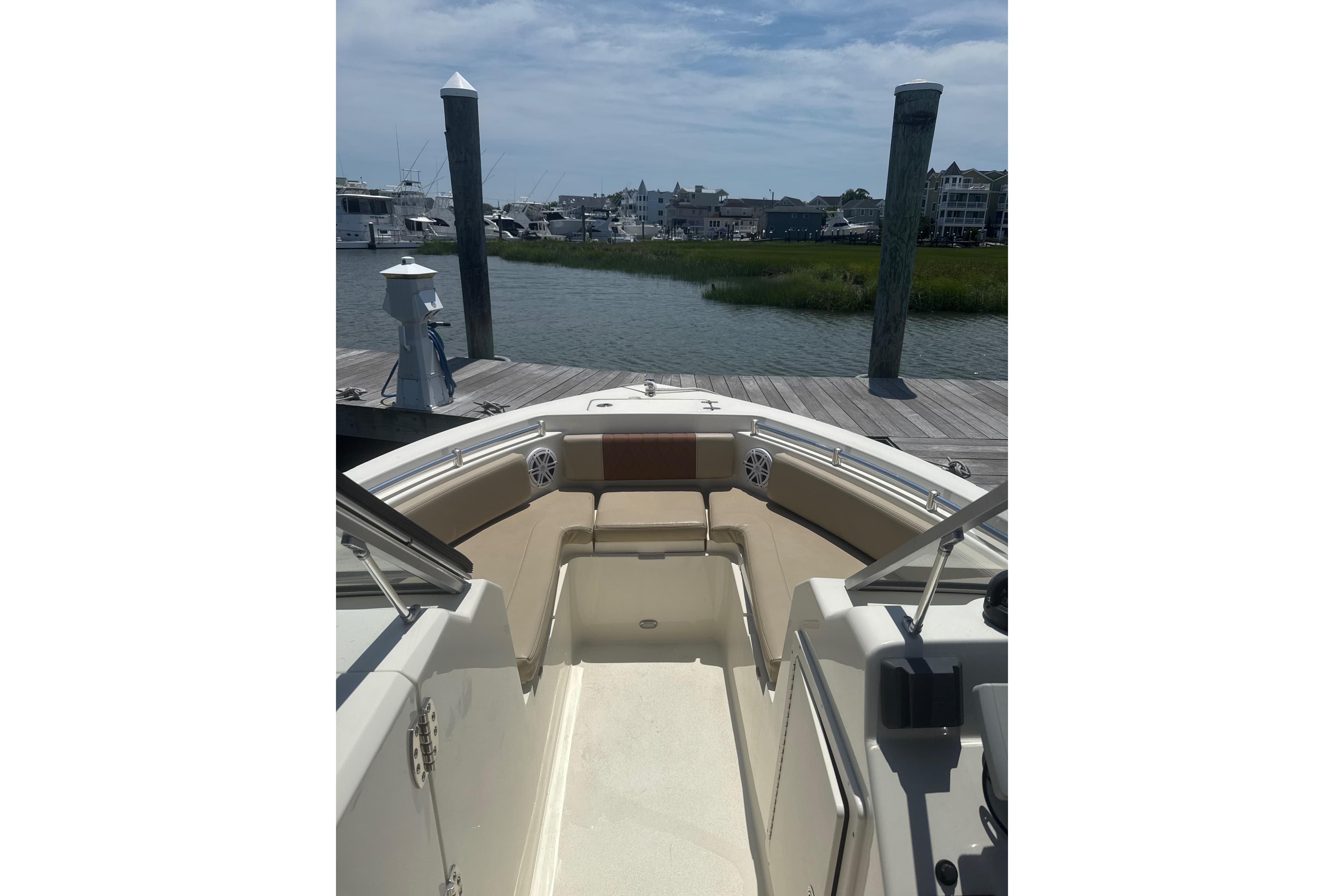 2024 Cobia 220 Dual Console boat docked by a scenic waterfront.