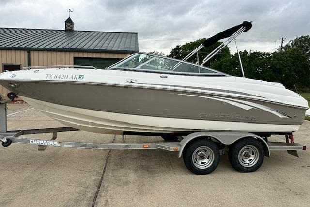 2007 Chaparral 204 SSi boat on trailer, parked outdoors, overcast sky.