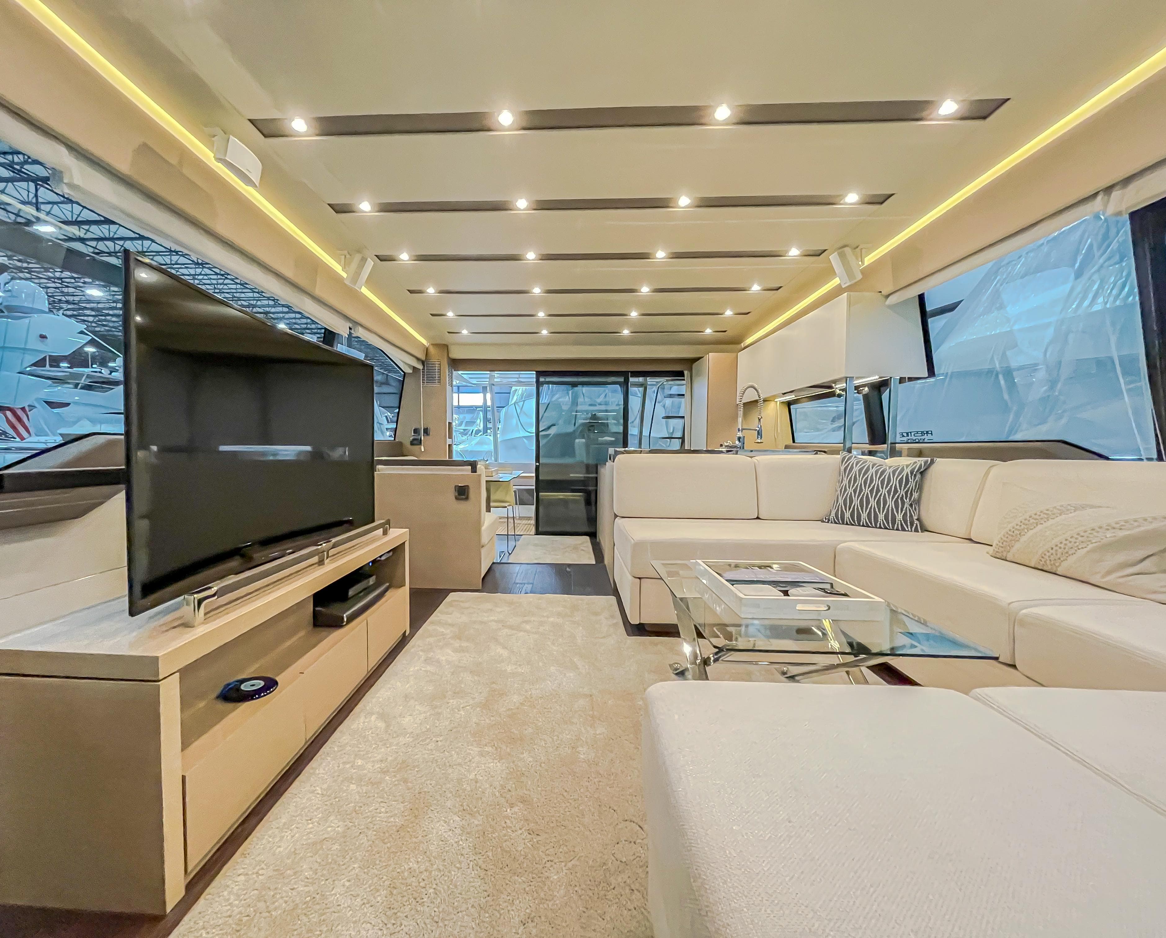 Luxurious interior of 2016 Prestige 680 Flybridge yacht with modern furnishings and large TV.
