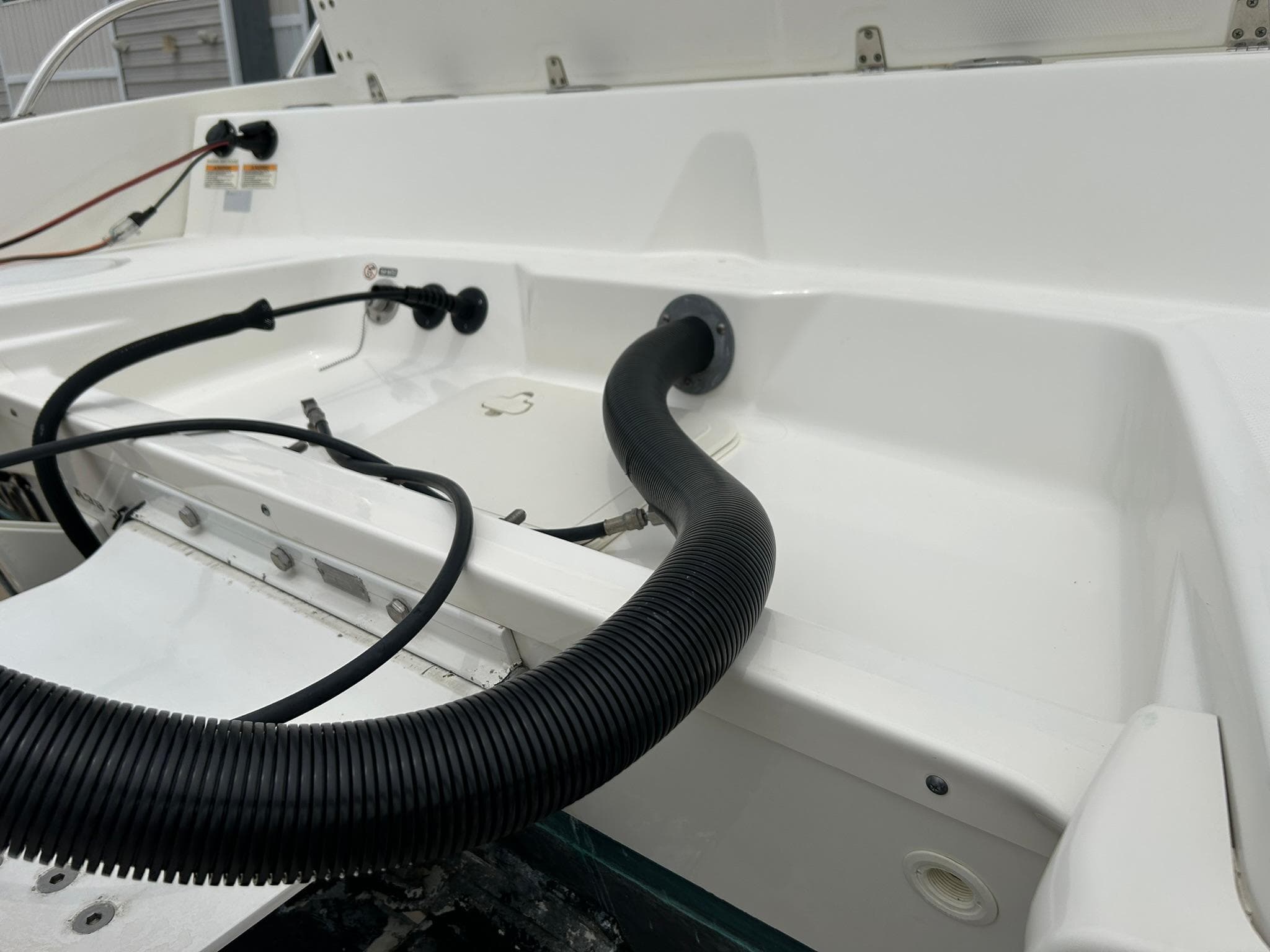2017 Boston Whaler 270 Dauntless boat interior with cables and hose connections.