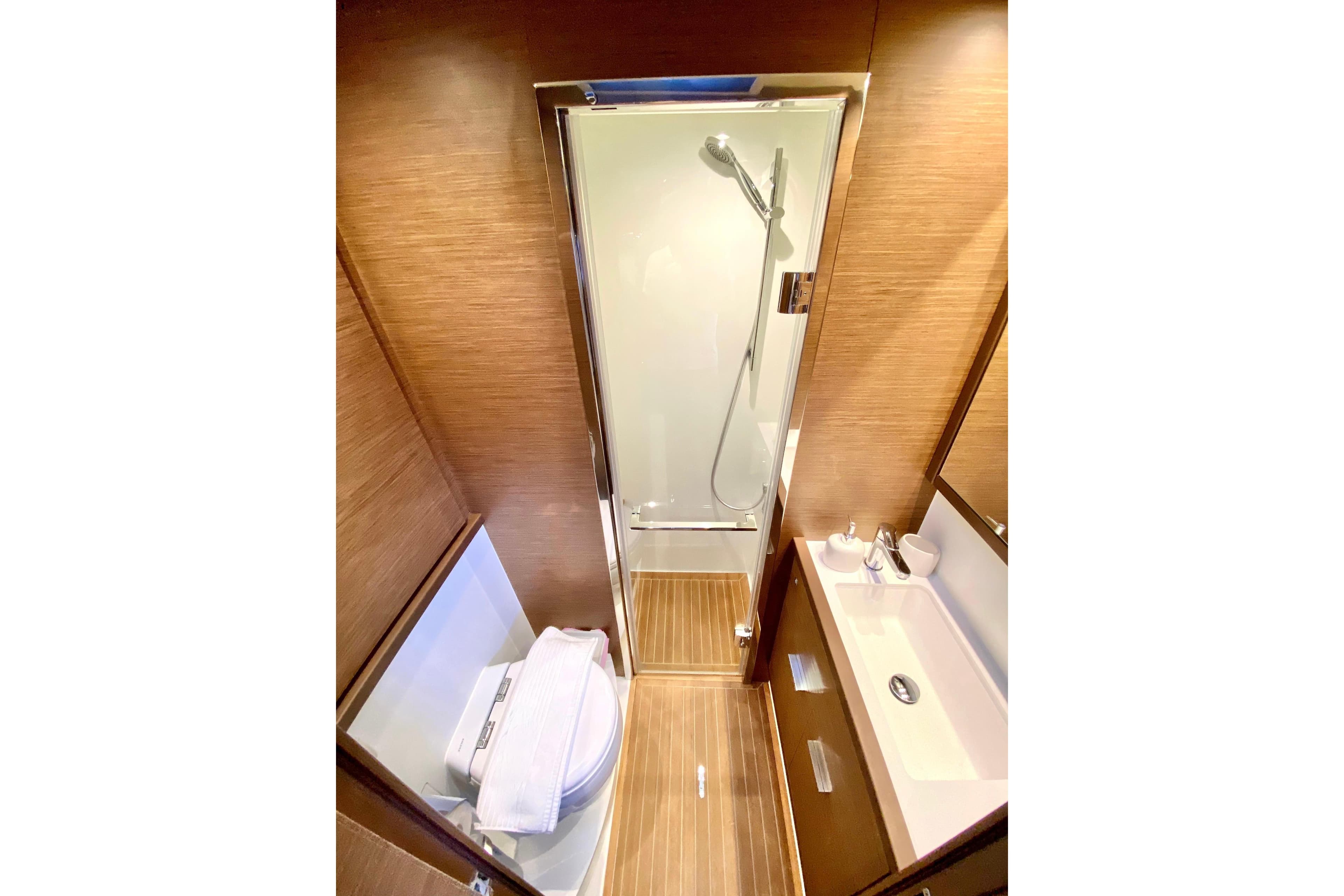 Luxurious bathroom in 2020 Lagoon 620 yacht with modern shower and wooden accents.