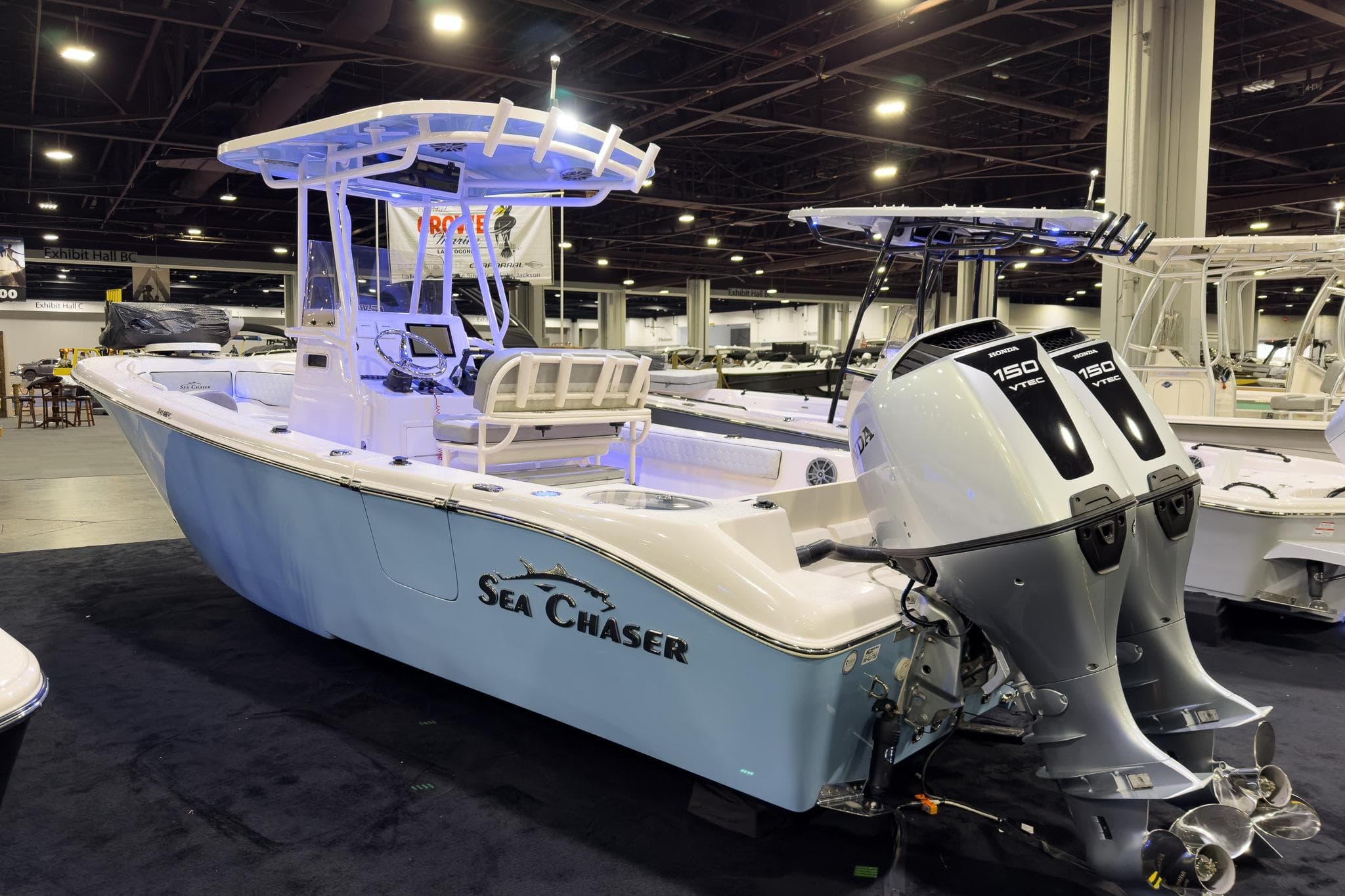 2026 Sea Chaser 24 HFC DE boat with dual Honda 150 engines at indoor exhibit.