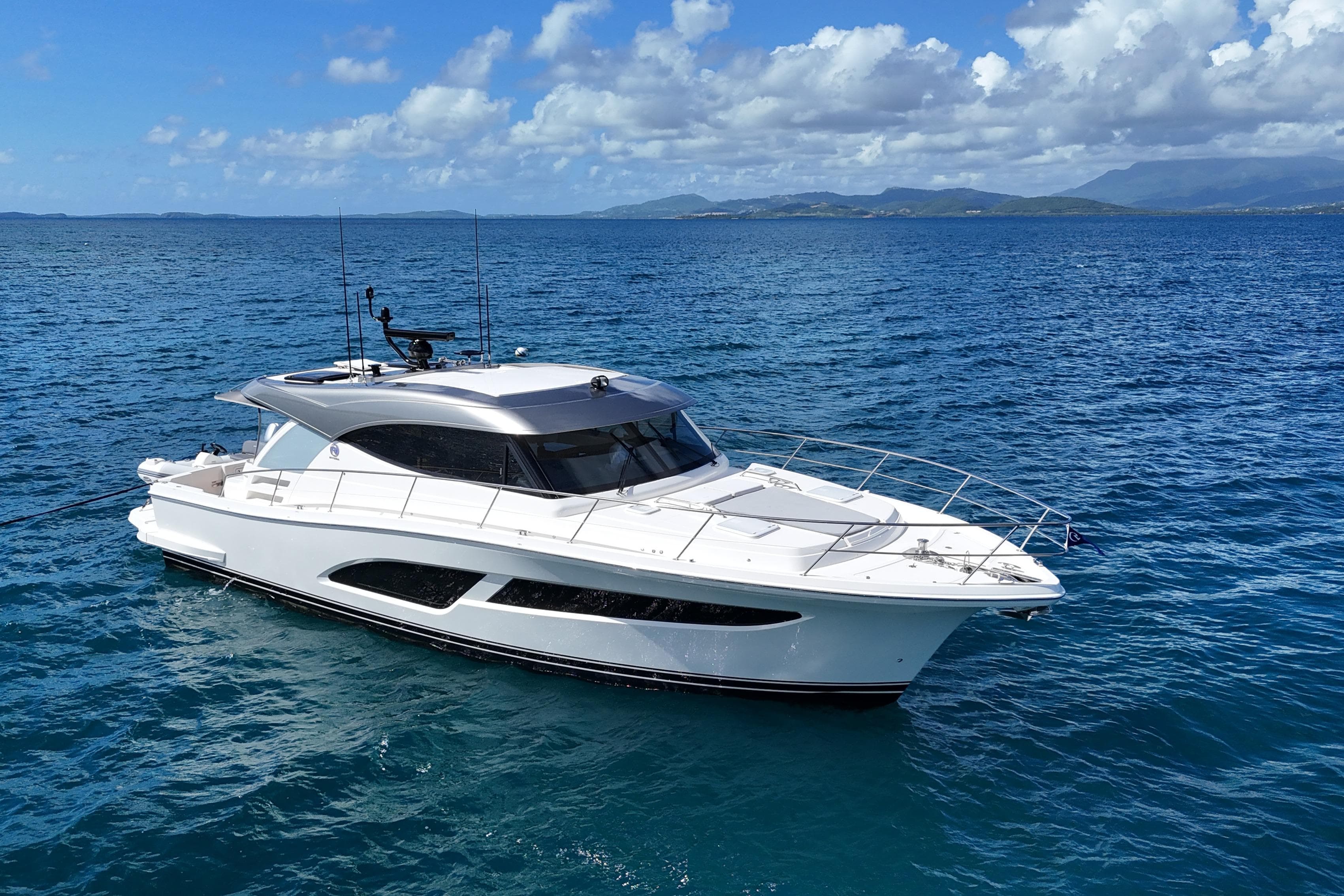 2023 Riviera 465 SUV yacht cruising on open blue sea under clear skies.