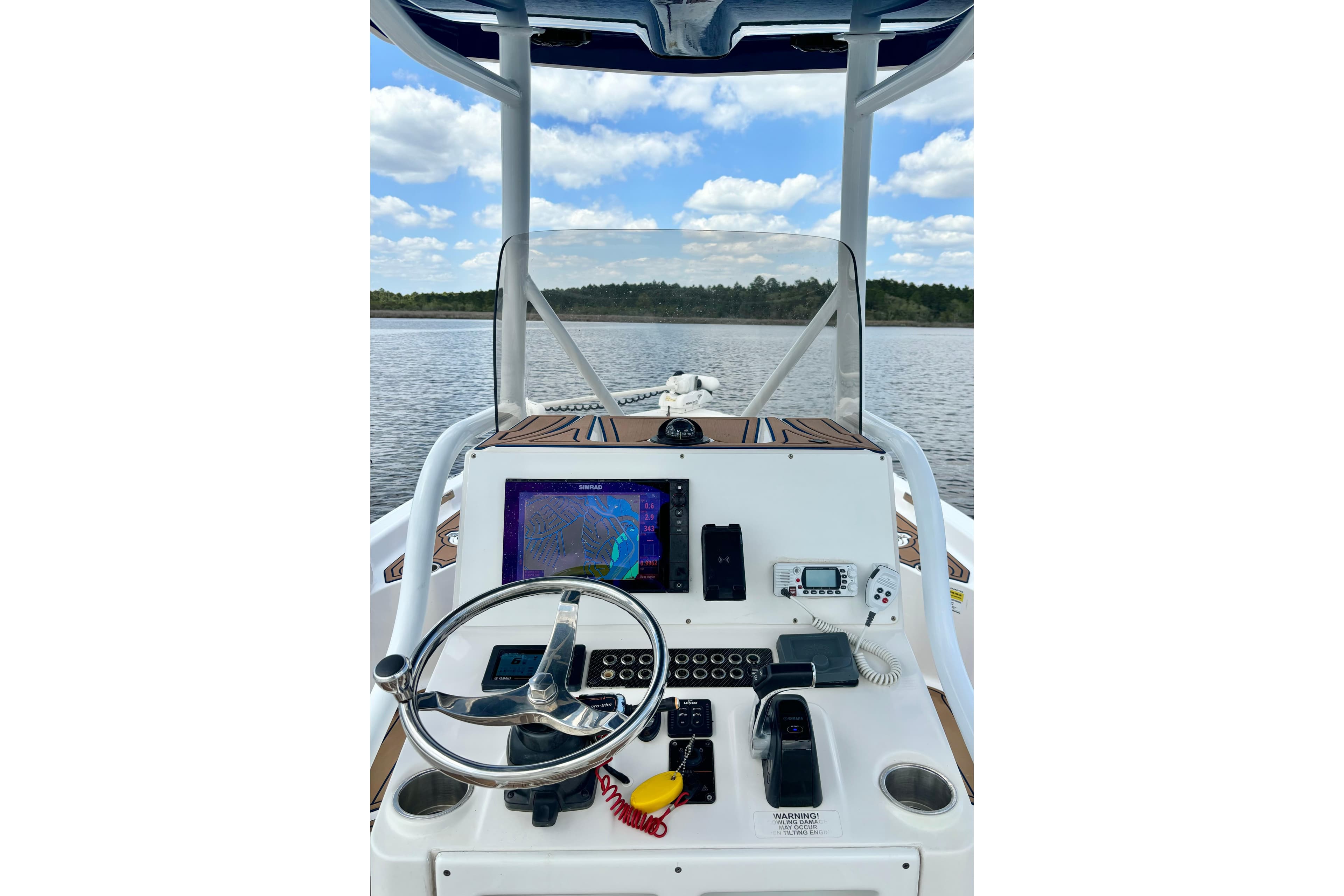 2021 Blue Wave 2600 PureBay boat dashboard with navigation equipment on a calm lake.