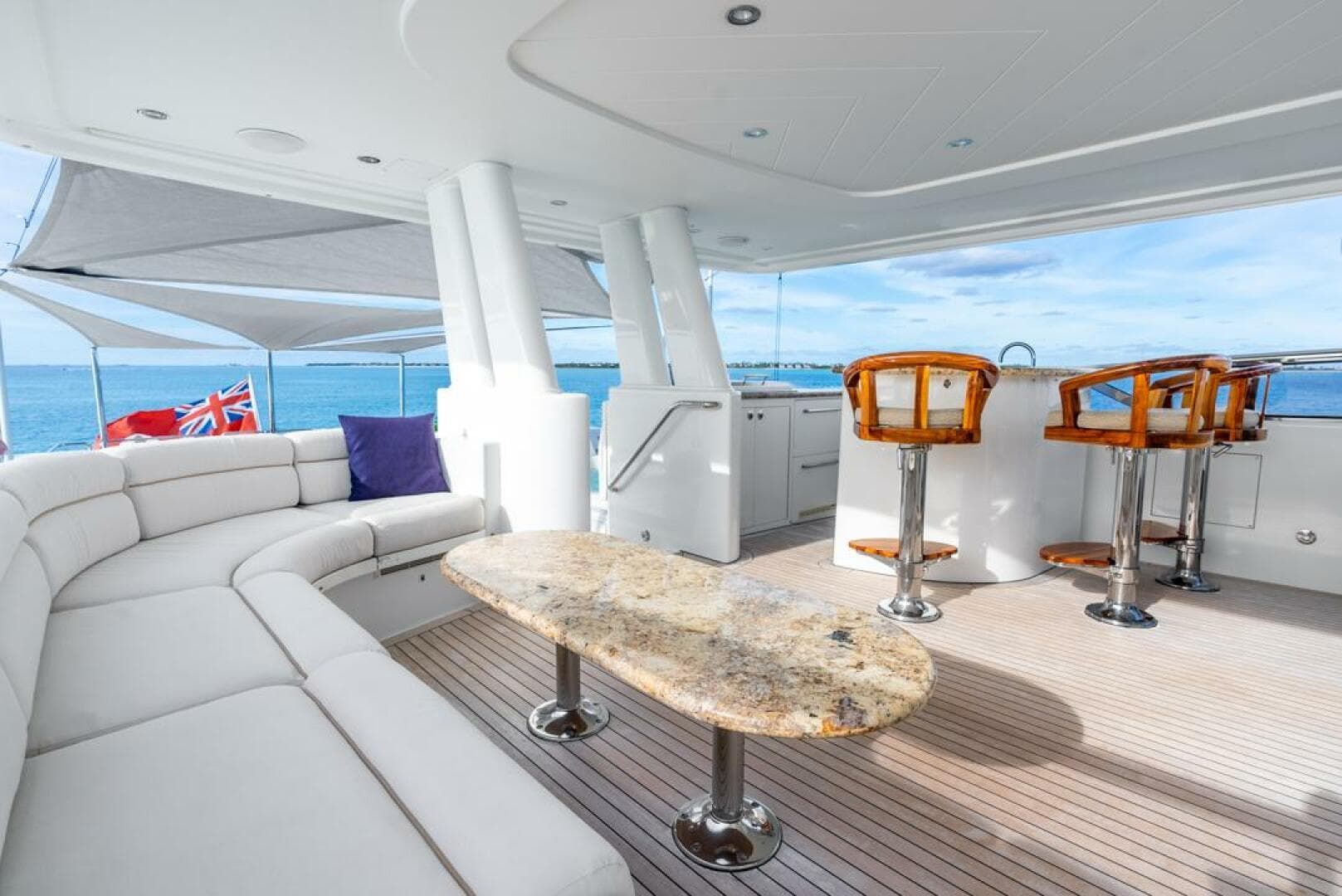 Luxurious 2012 Westport 112 yacht deck with elegant seating, bar stools, and ocean view.