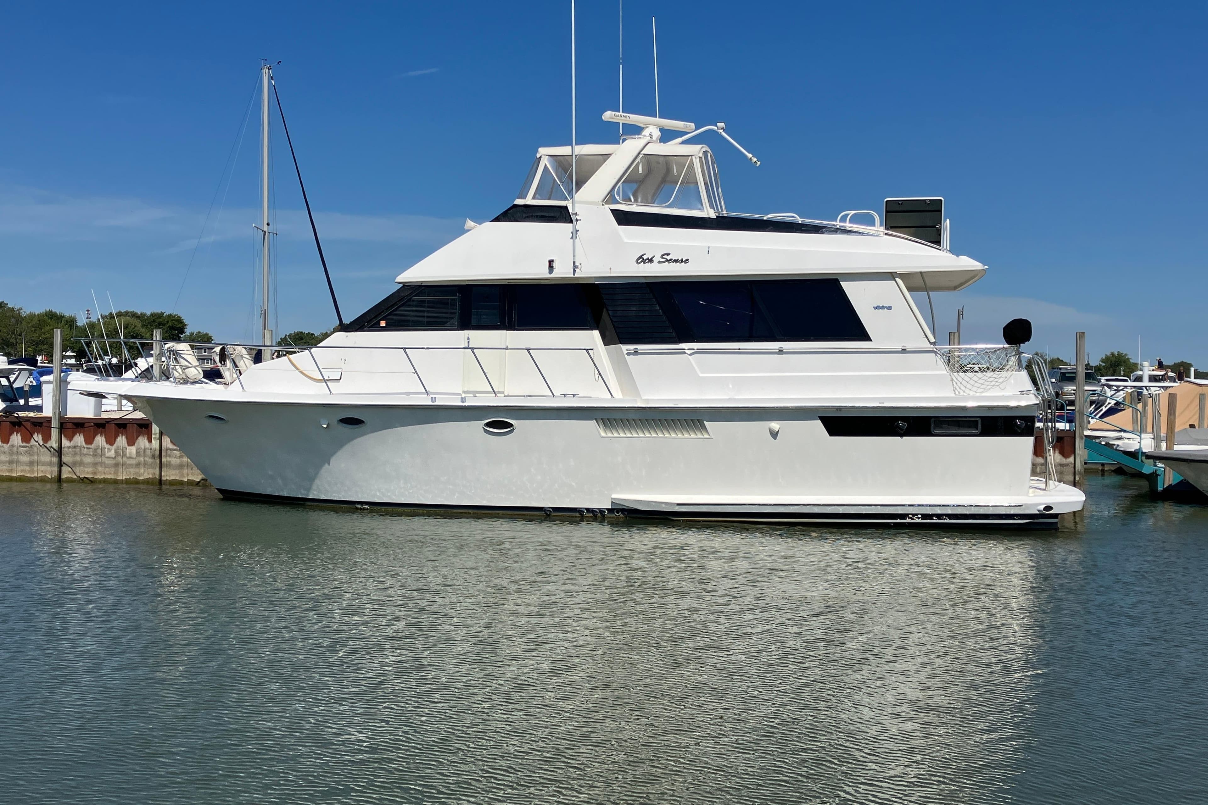 1995 Viking 50 Motor Yacht docked in a marina under clear blue skies.
