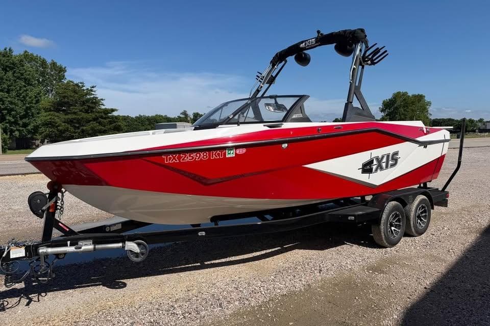 2022 Axis T220 boat in red and white on a trailer, parked outdoors.